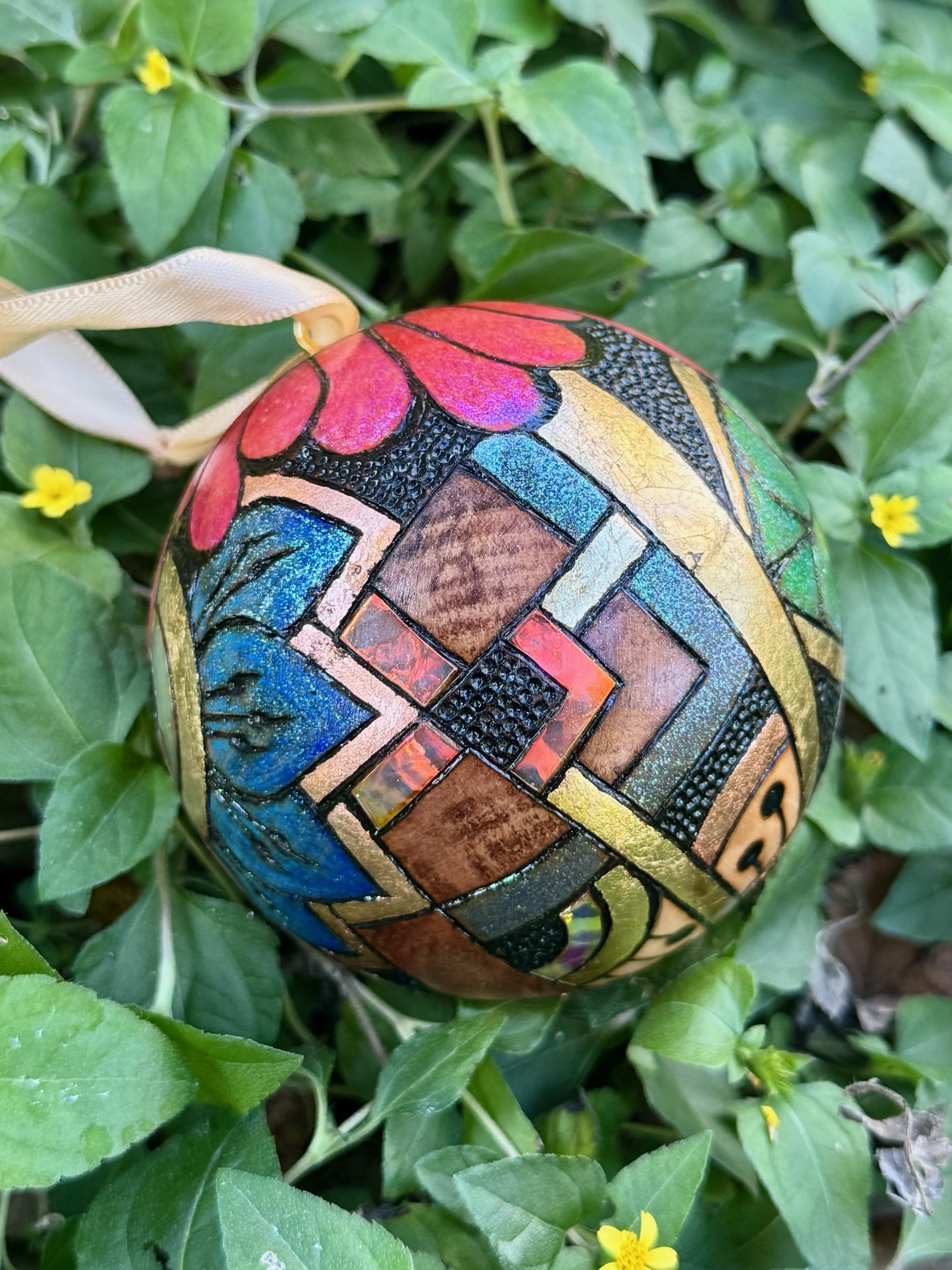 Luminous wood orb by Anne Shackelford, nature-inspired pyrography with pigment and light reflection.