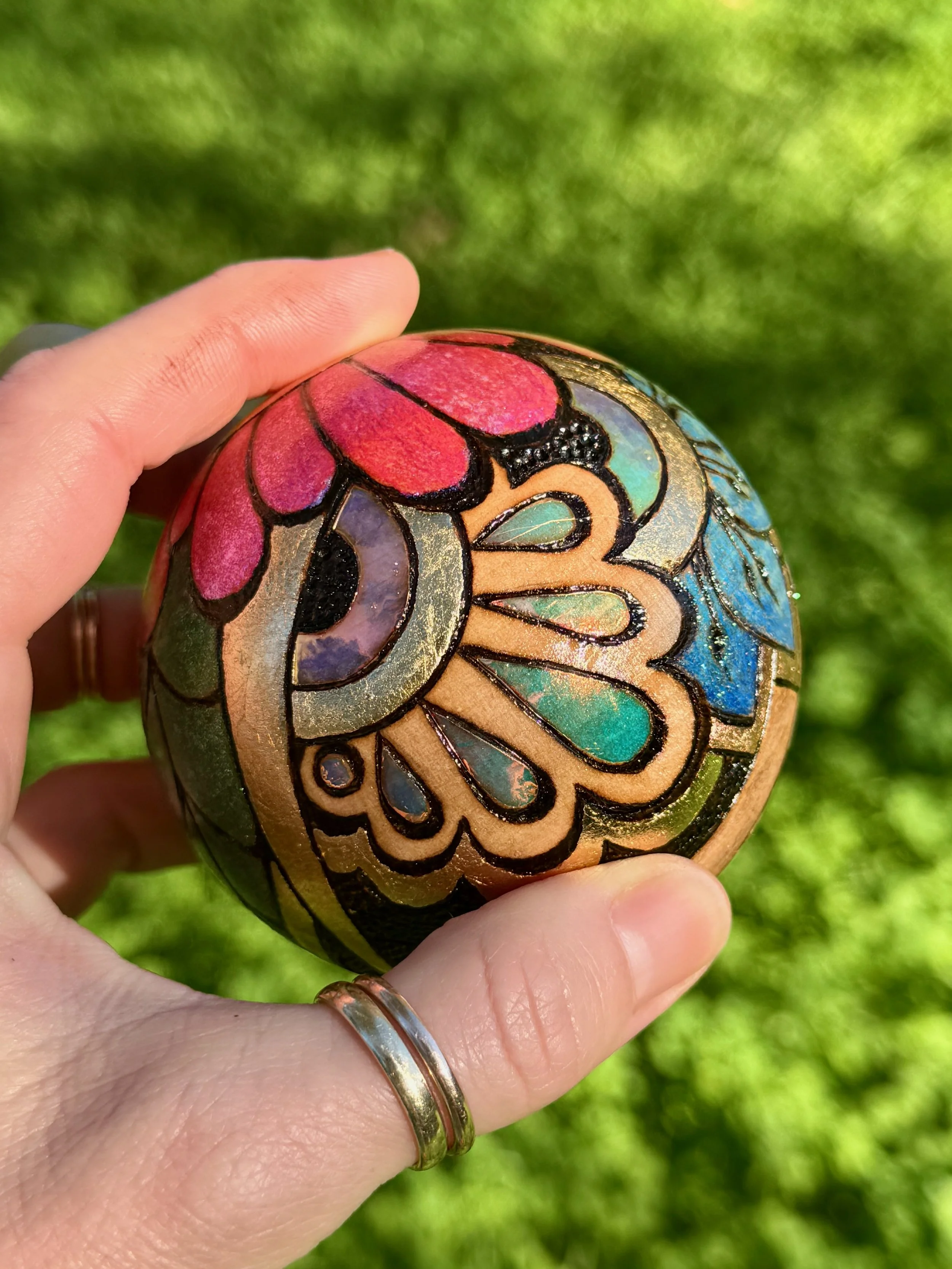 Shimmering ornament from the Firelight Collection, created through pyrography and gilded detail.