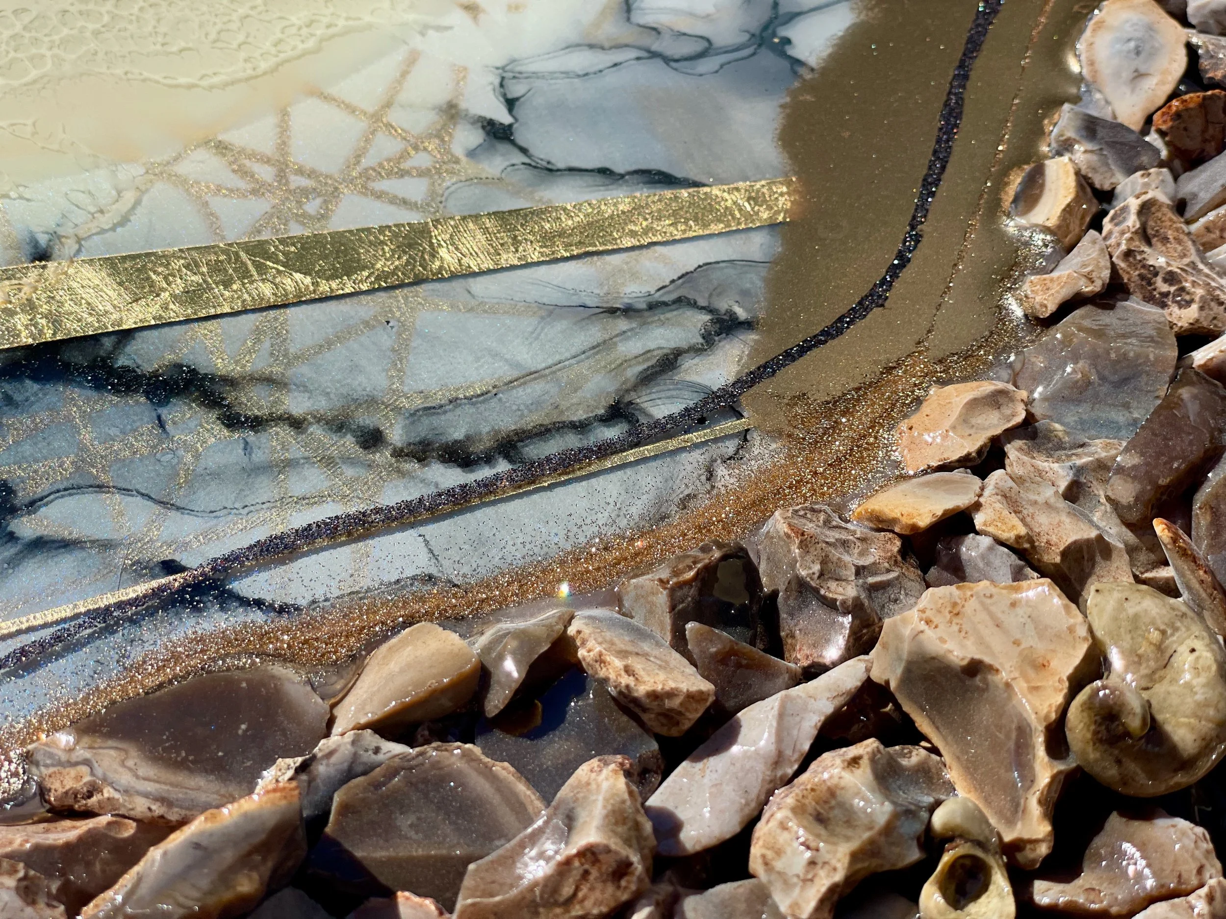 Abstract wall art by Austin artist Anne Shackelford incorporating stone, shell, and flowing resin.