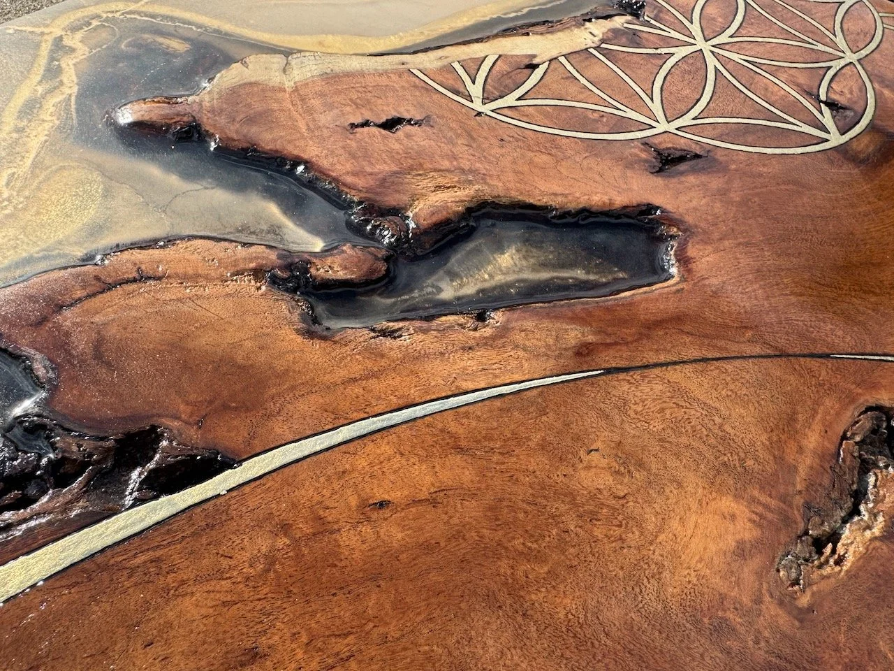 Sun-inspired textures of metal leaf and polished resin reflecting light across carved and burned Mesquite wood.