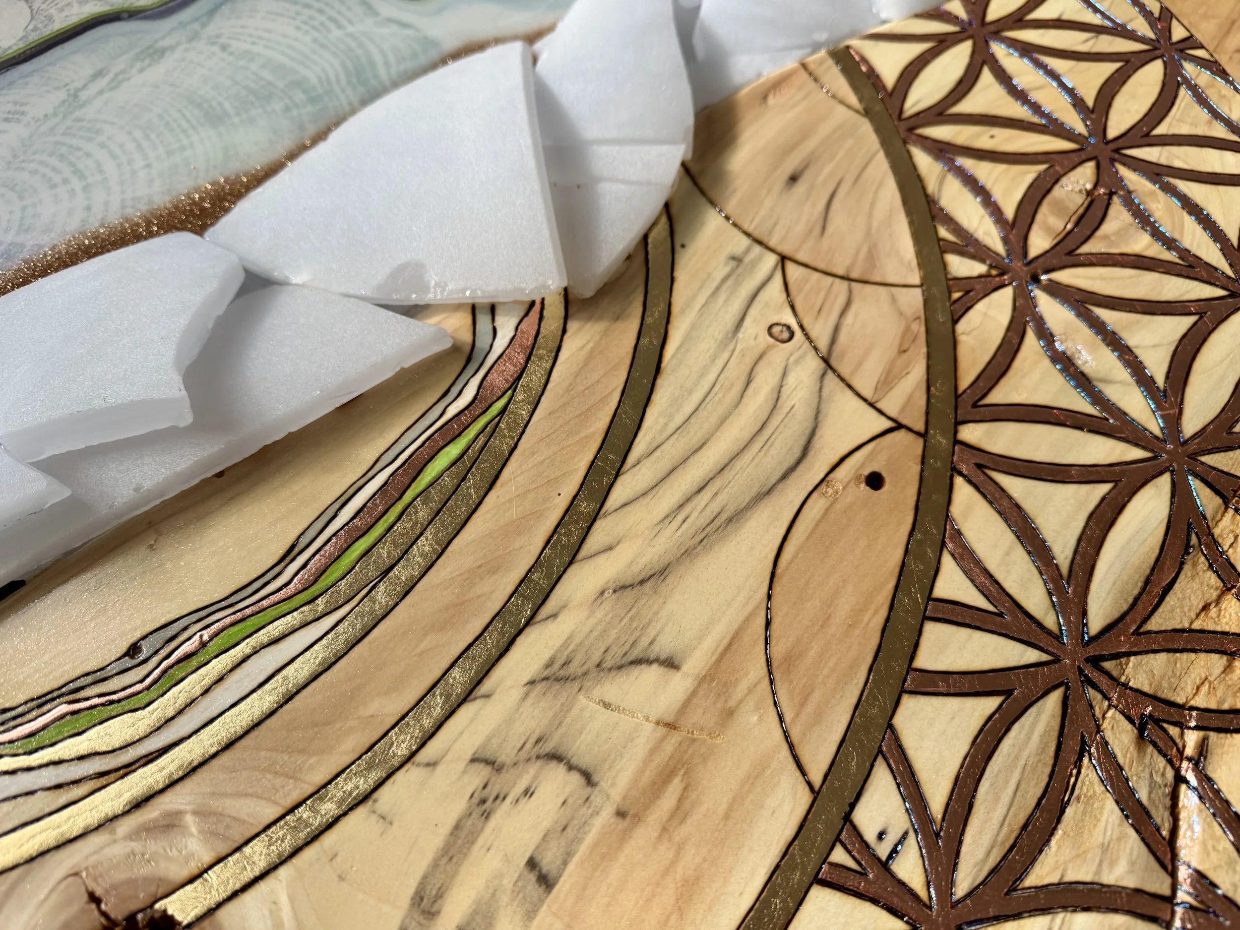 Pyrography burned into aspen wood beneath layered resin surface