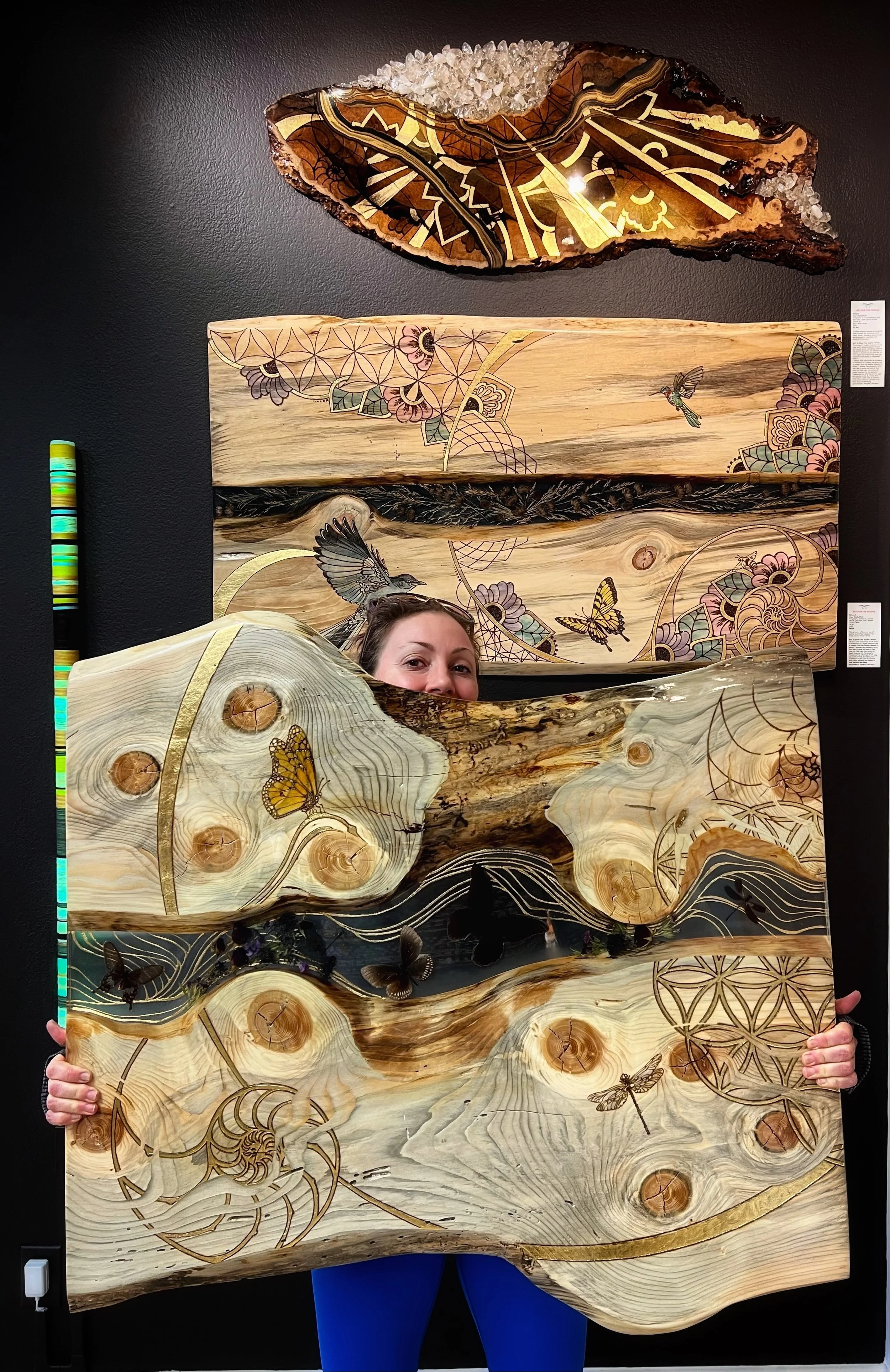 Anne Shackelford pictured with Lovers Carvings wall art, aspen wood and resin piece from the Firelight Collection.