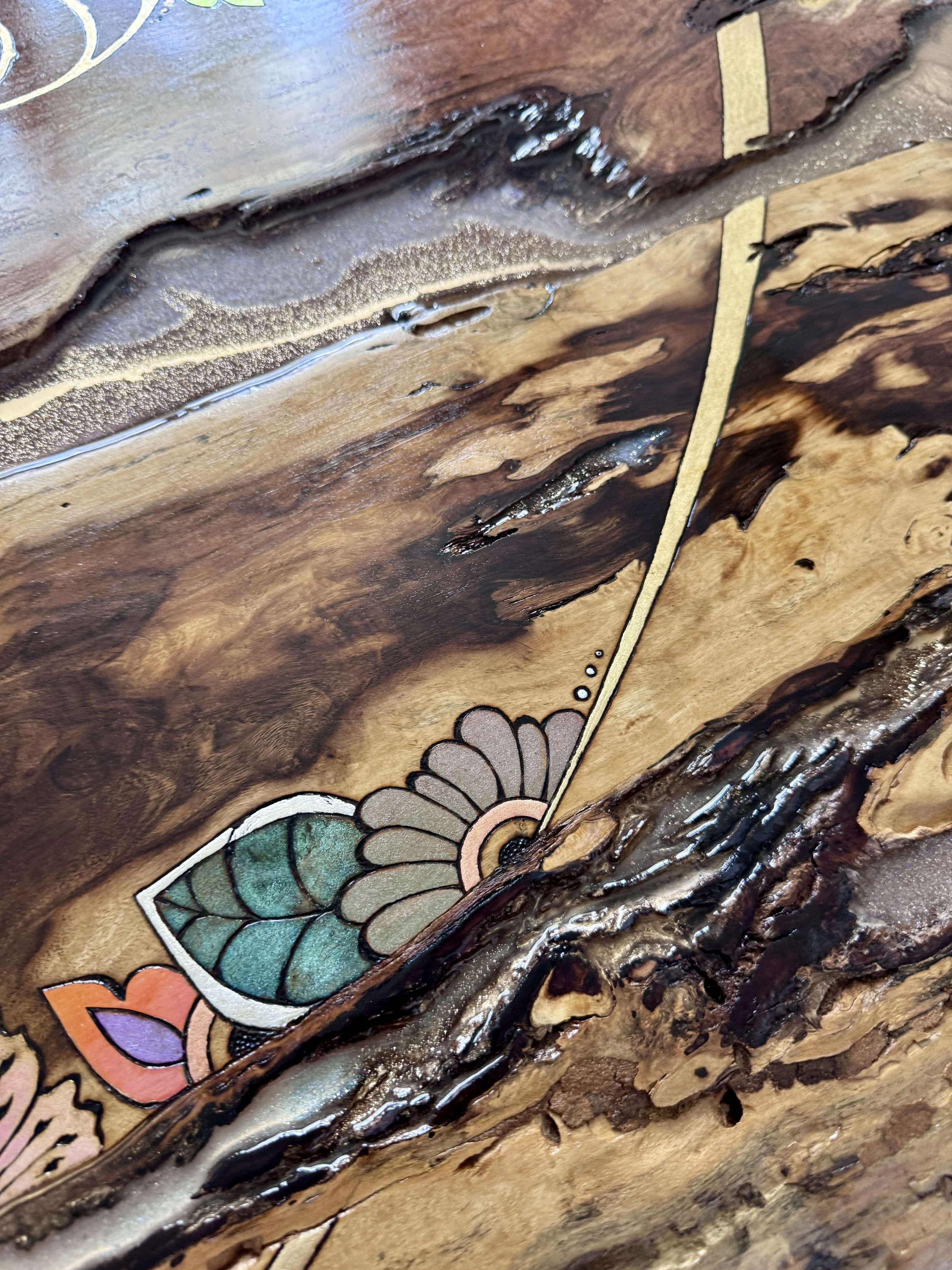 Close-up of botanical pyrography, natural wood grain and metal leaf details in a light-responsive mixed media artwork.