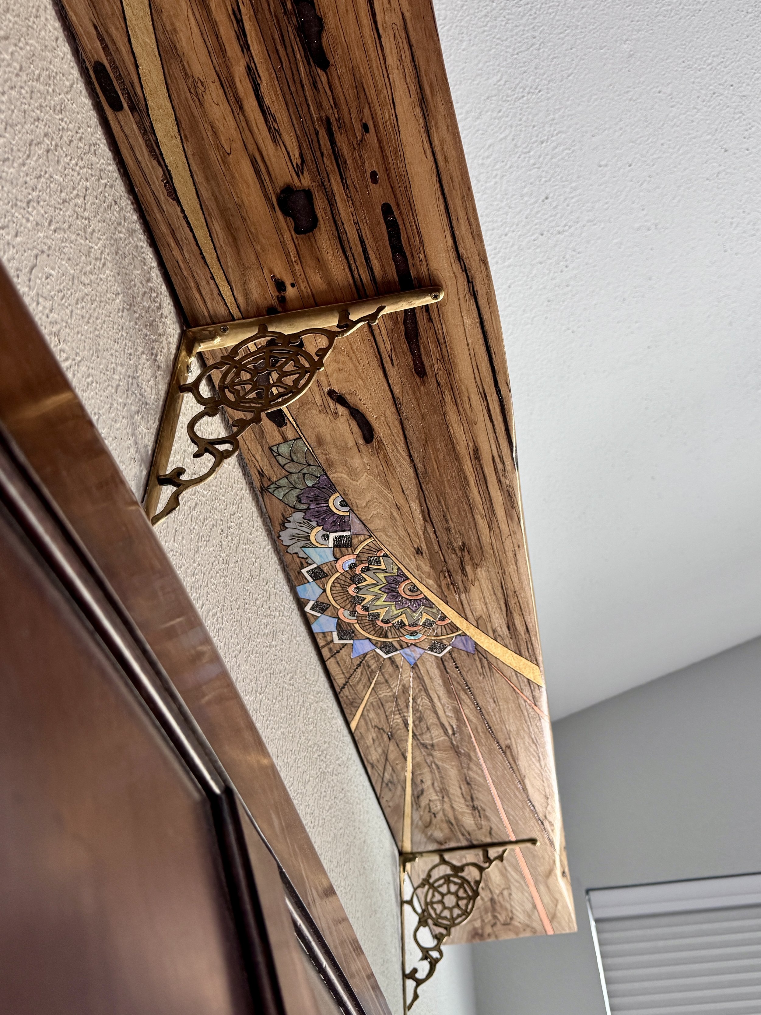 Storyteller by Anne Shackelford displayed above a bed, handcrafted from a live-edge slab of Texas pecan with books, crystals, and plants.