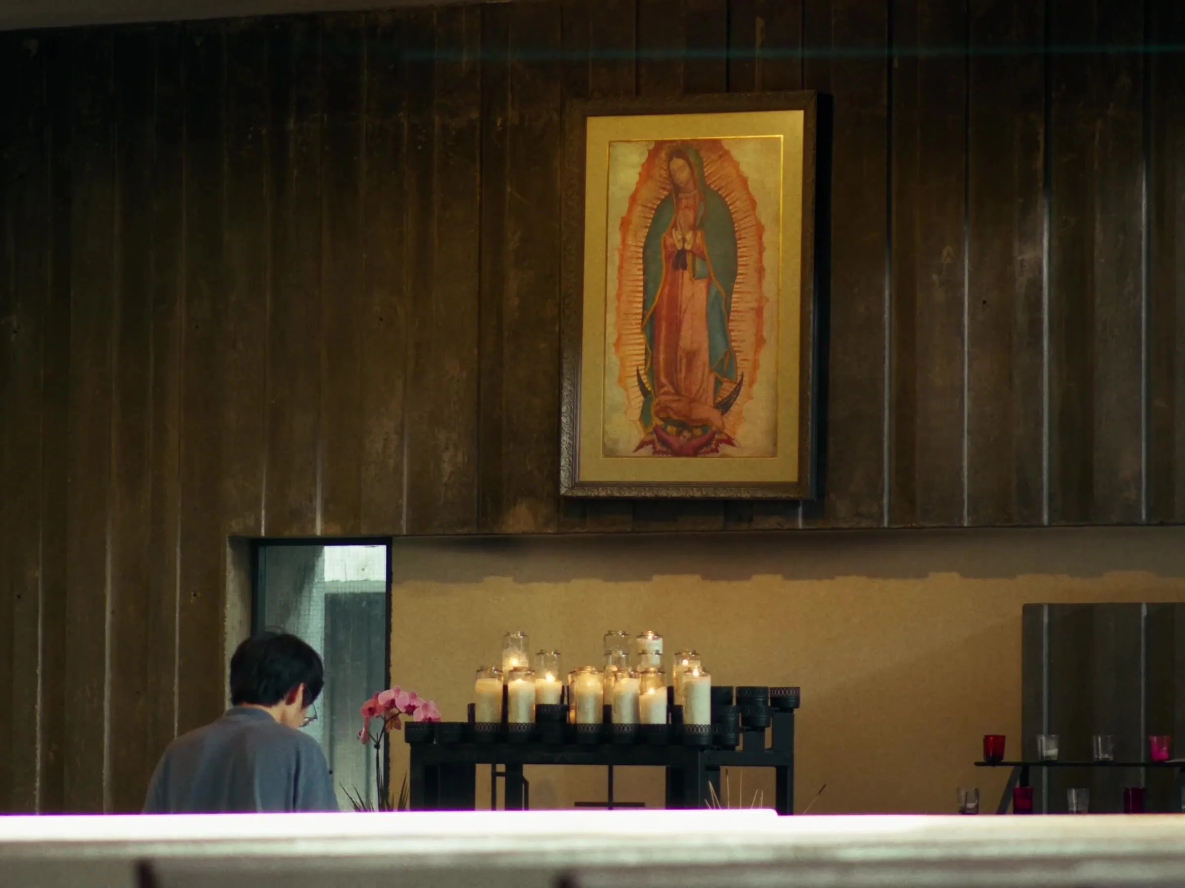 Our Lady of Guadalupe shrine with votive candles in the Newman Hall chapel. Photo by @reagancalaguasfilm