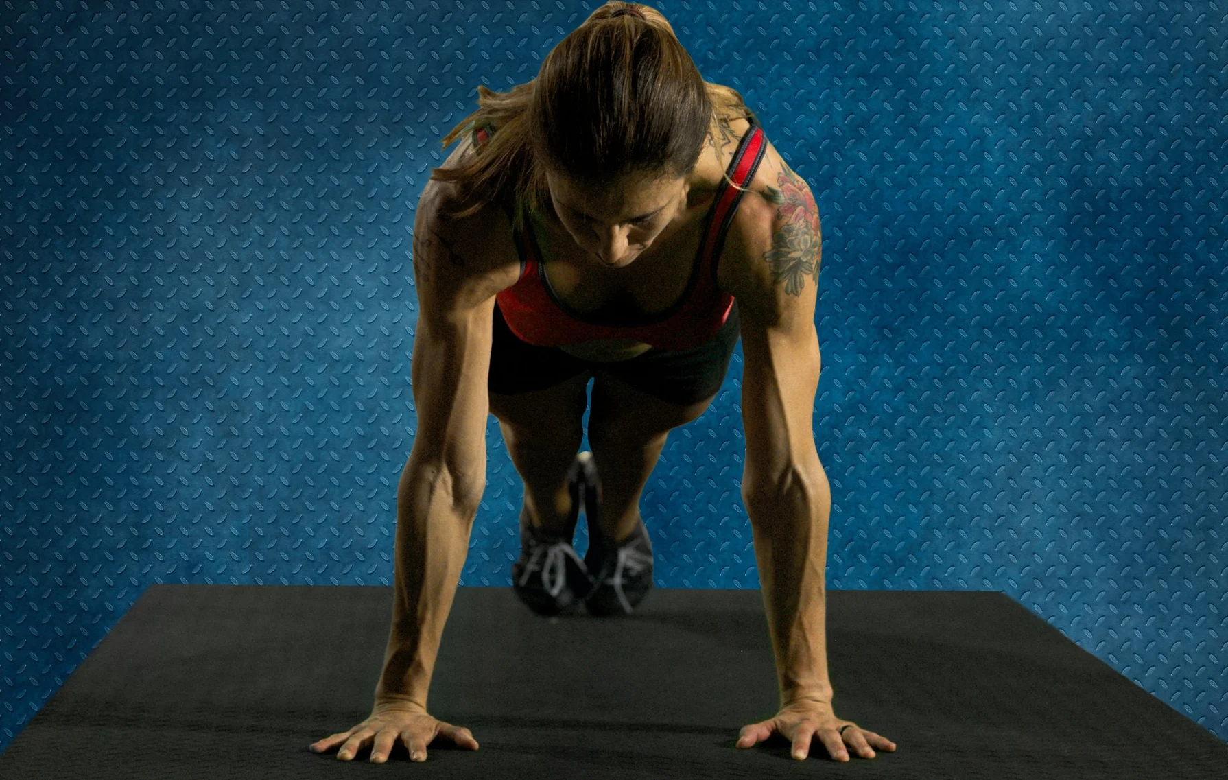 Correct pushup form (setup position): fingers forward, elbows spun mostly back, feet together, head neutral.