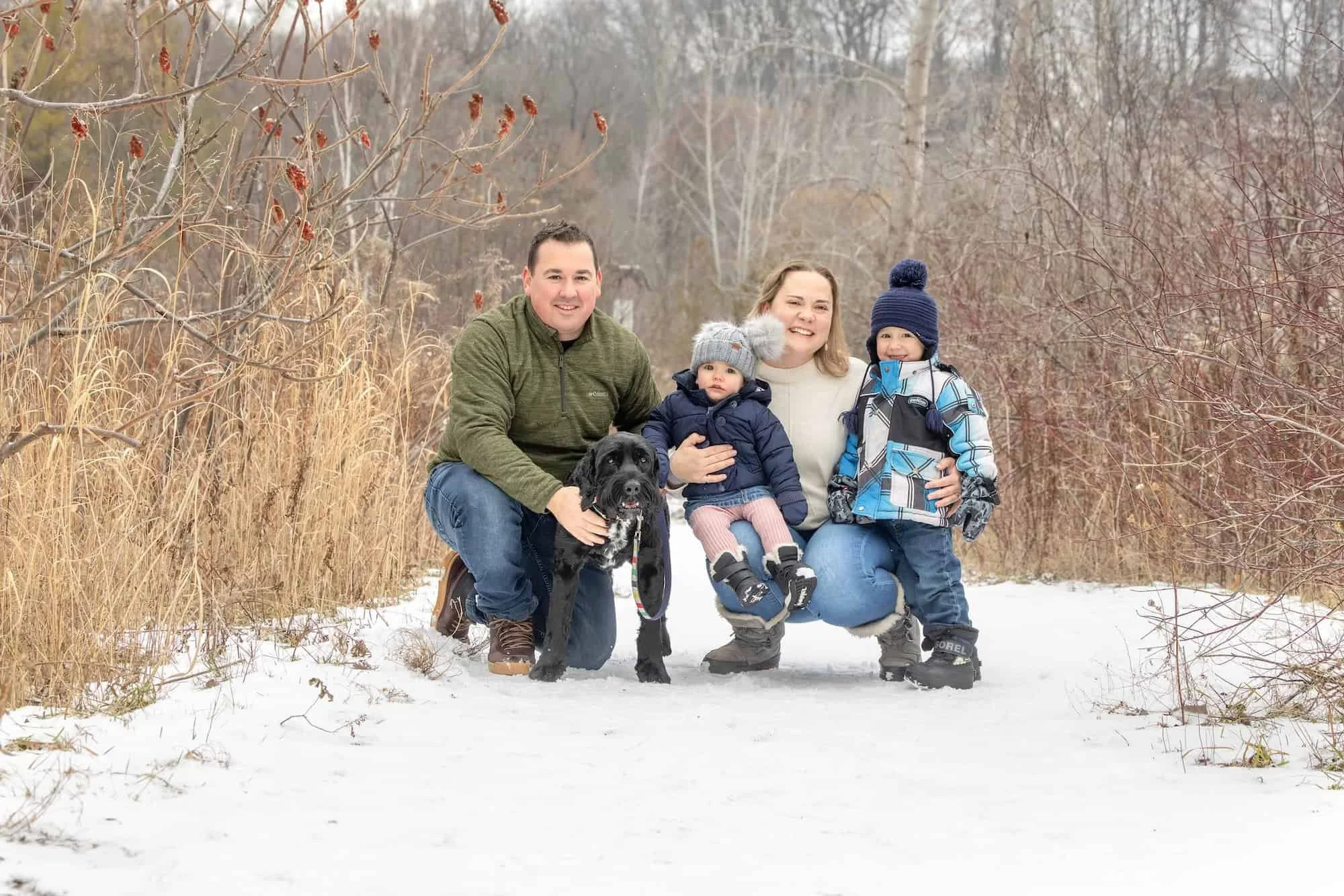 family with their dog on a snowy day in Toronto