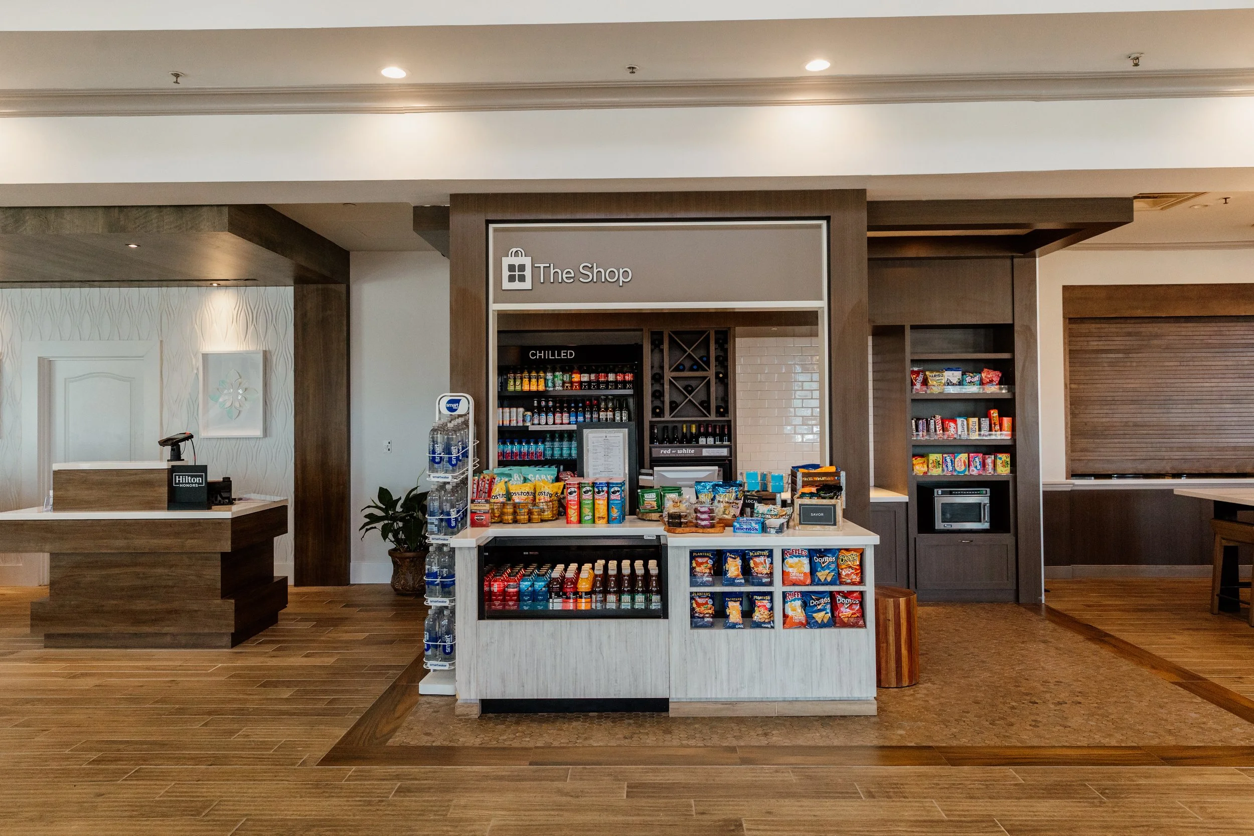 Convenience shop area with snacks, drinks, and water bottles inside a hotel lobby.