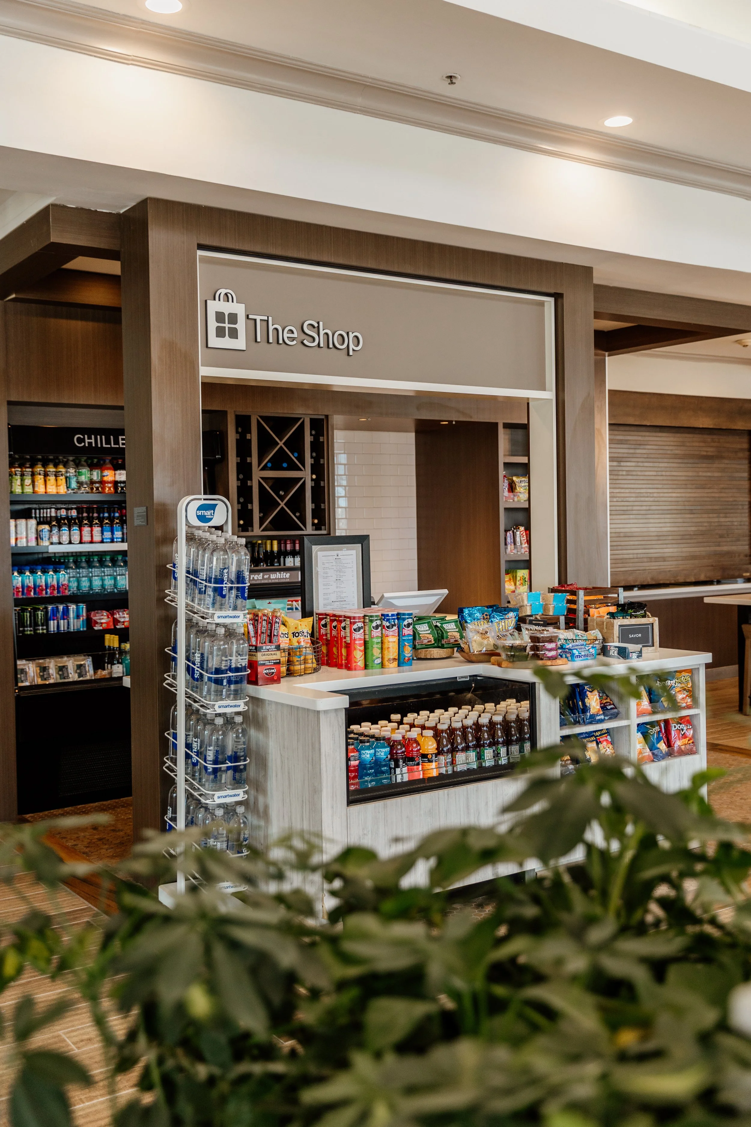 Small store labeled 'The Shop' with snacks, drinks, and bottled water inside