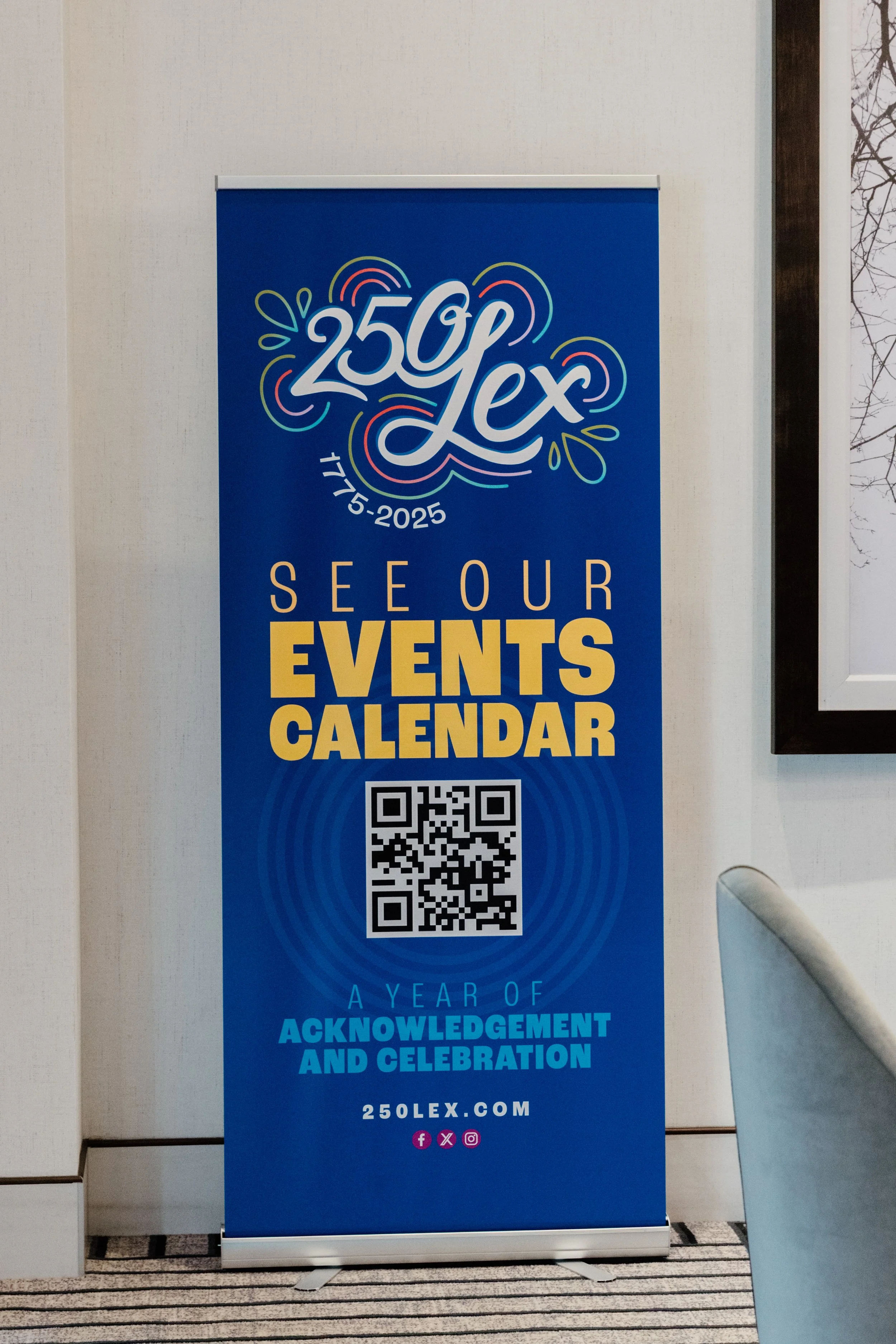 Blue vertical banner promoting 250Lex's events calendar with a QR code, celebrating a year of acknowledgment and celebration, featuring colorful logo and social media icons.