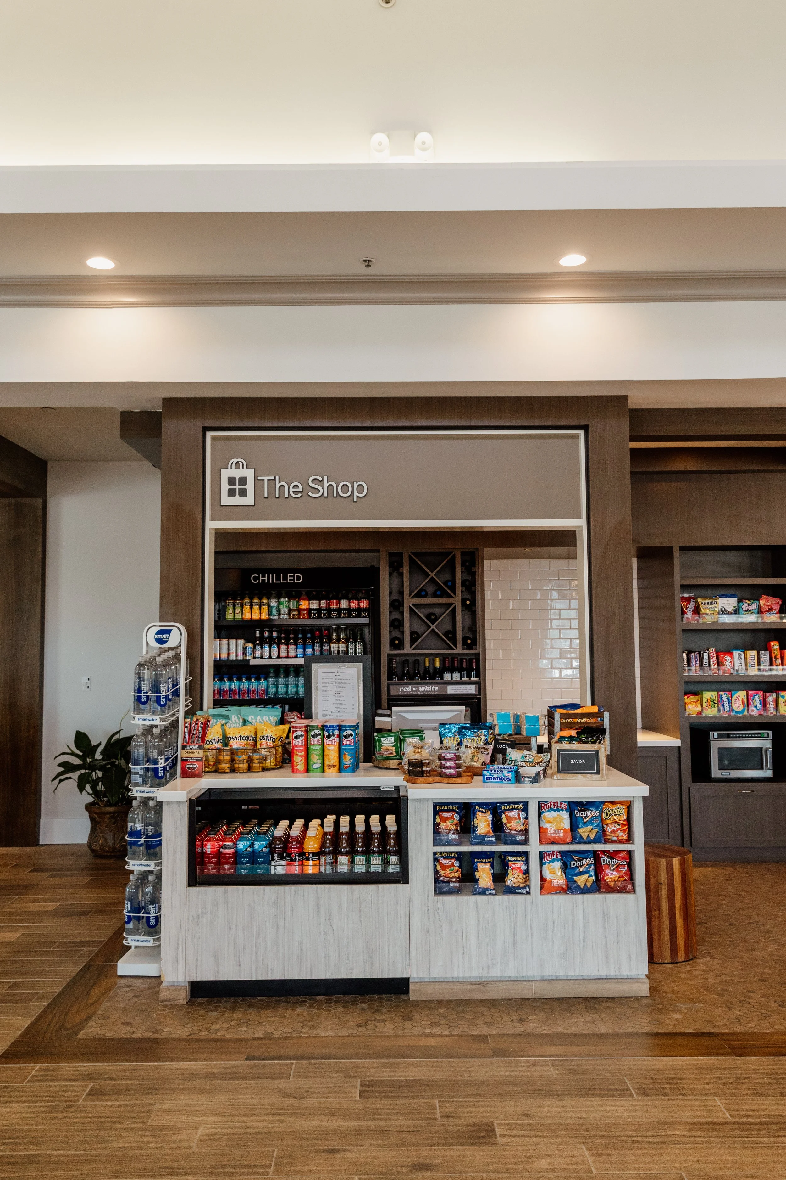Small convenience shop with beverages, snacks, and candy on display within a hotel or resort lobby area.