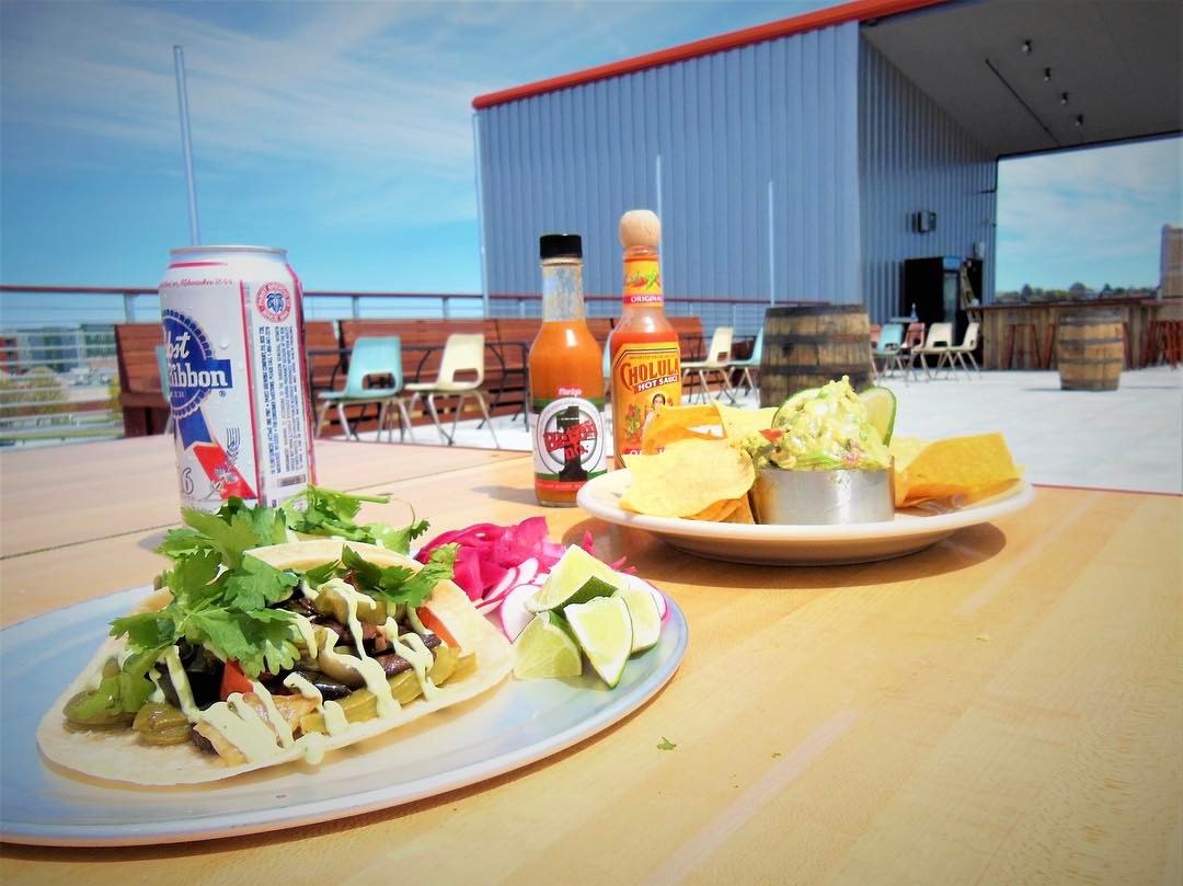 Tacos and a can of PBR on a rooftop bar