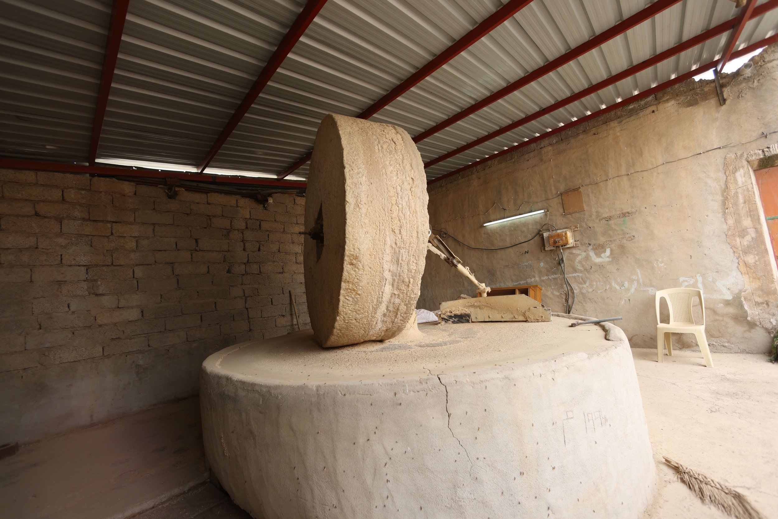 Villagers use the time-honored method of stone milling for grinding grains.  