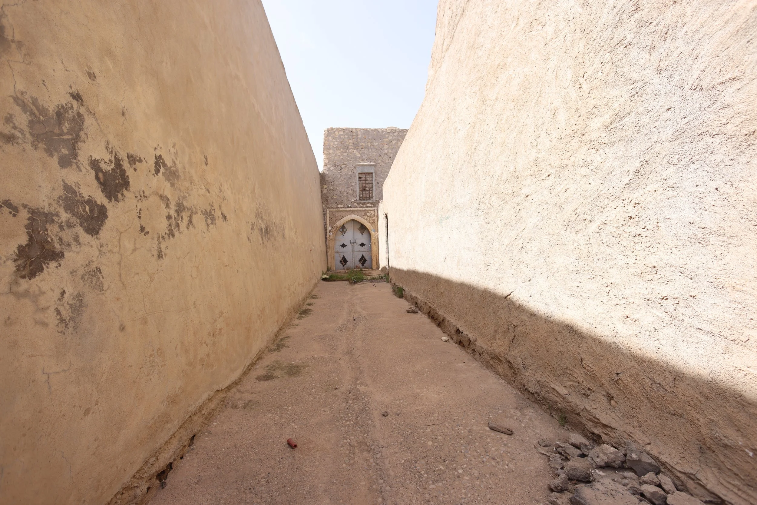  As with many northern Iraqi towns and villages, pathways have walls to protect from the elements and provide shade, and the homes sport ornate painted doors. 