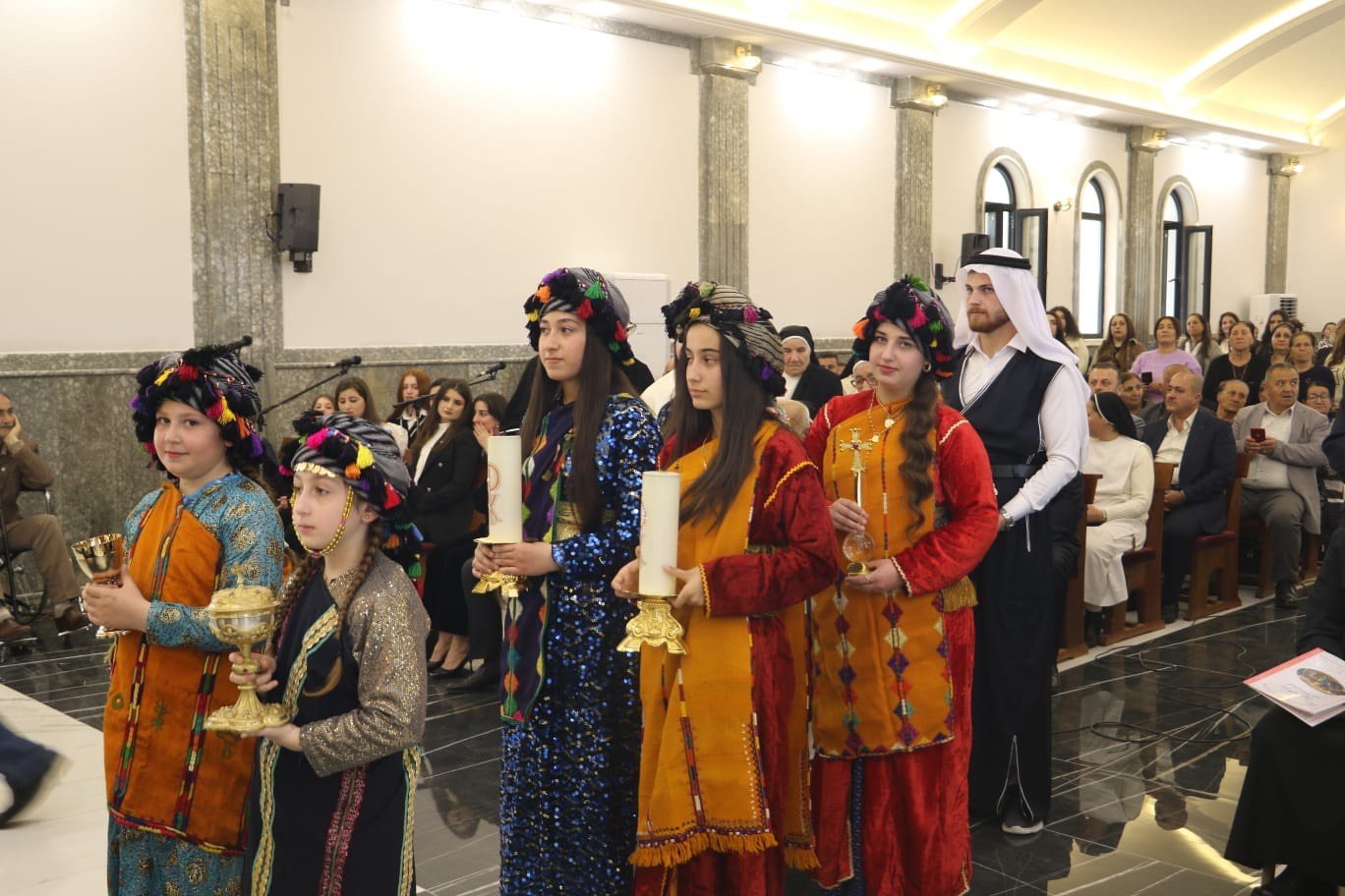  Young girls in traditional Chaldean attire presenting the chalice and the Holy Host to the bishop. 