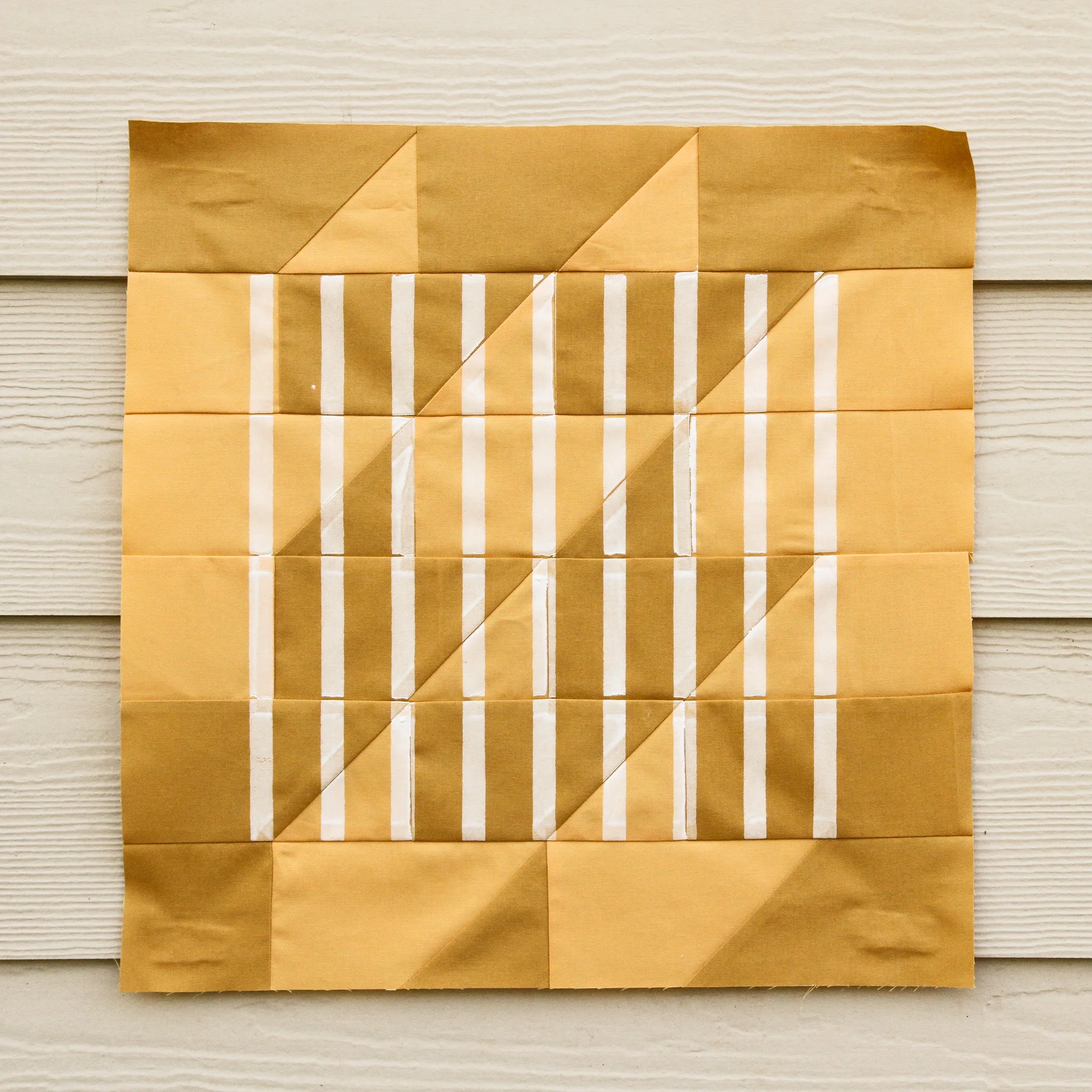 Graphic white stripes screen-printed onto a mustard quilt | by Kelsey Boes