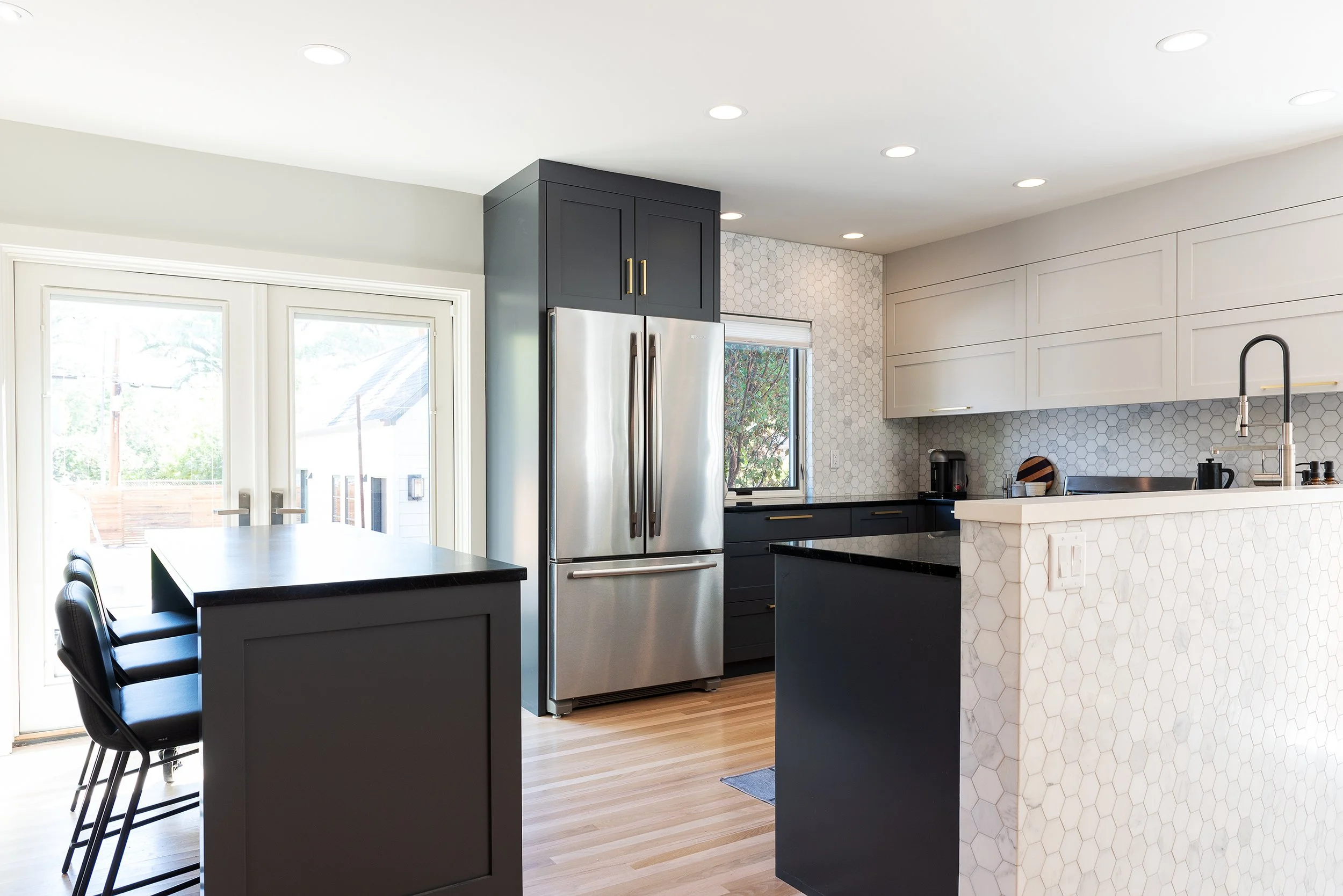 Fridge centered on the photo with blue gray custom cabinetry surrounding and golden hardware.
