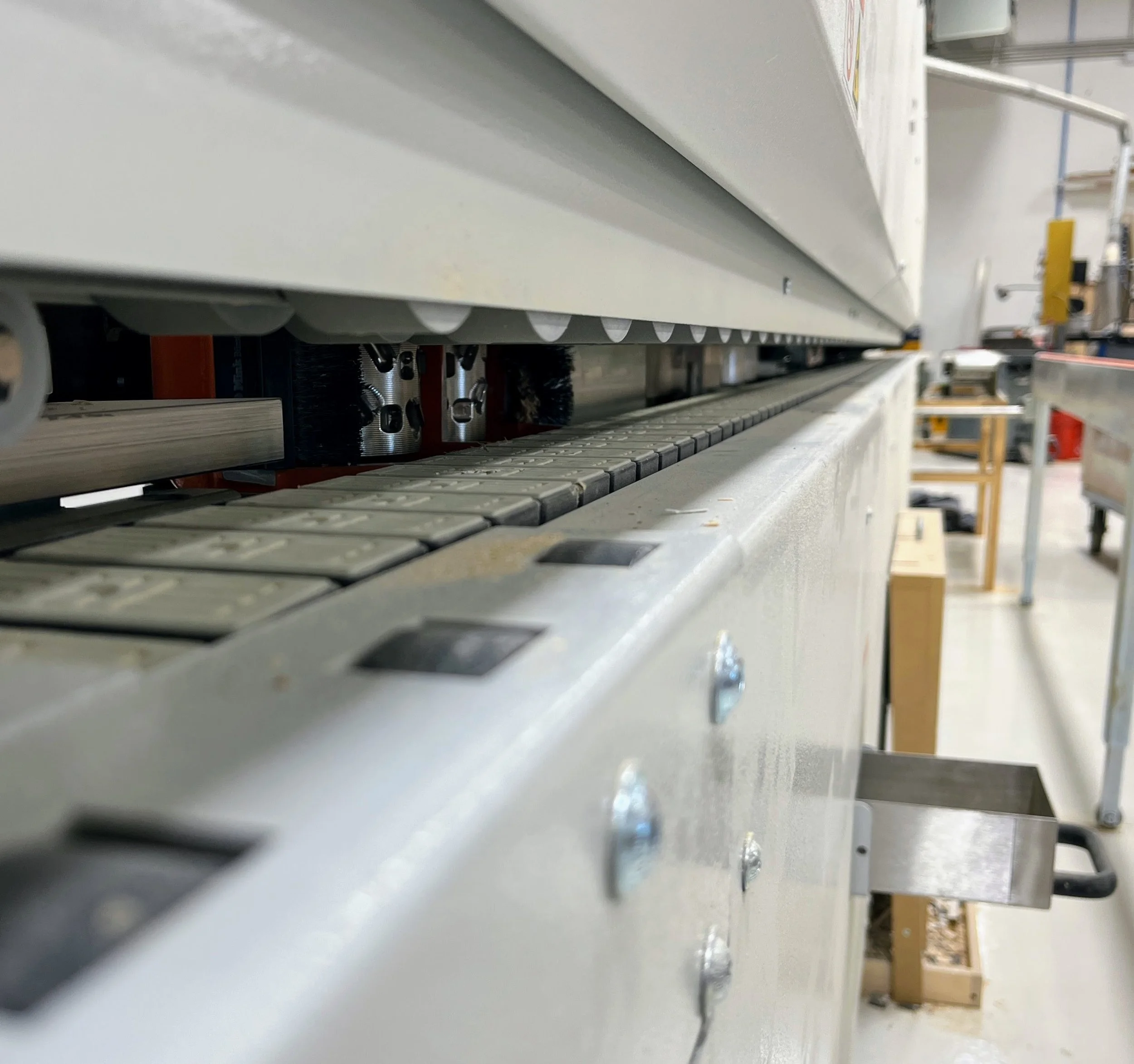 View looking down the length of an edge bander machine.