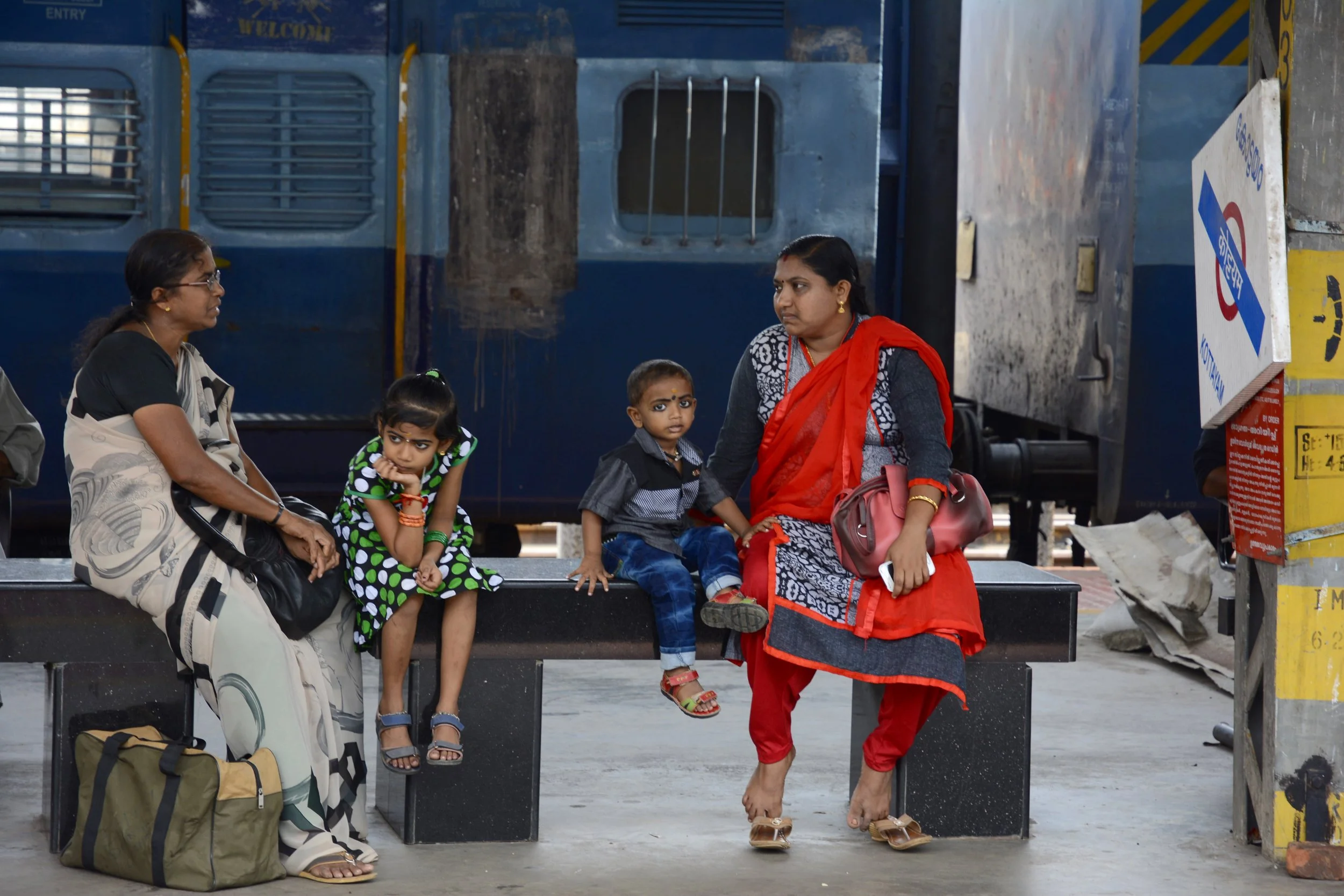 Mother and children at train station.