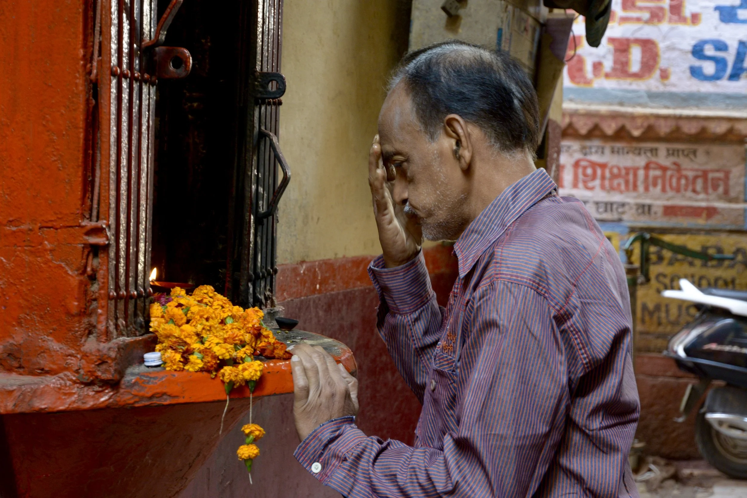 In prayer at a shrine behind the ghats.
