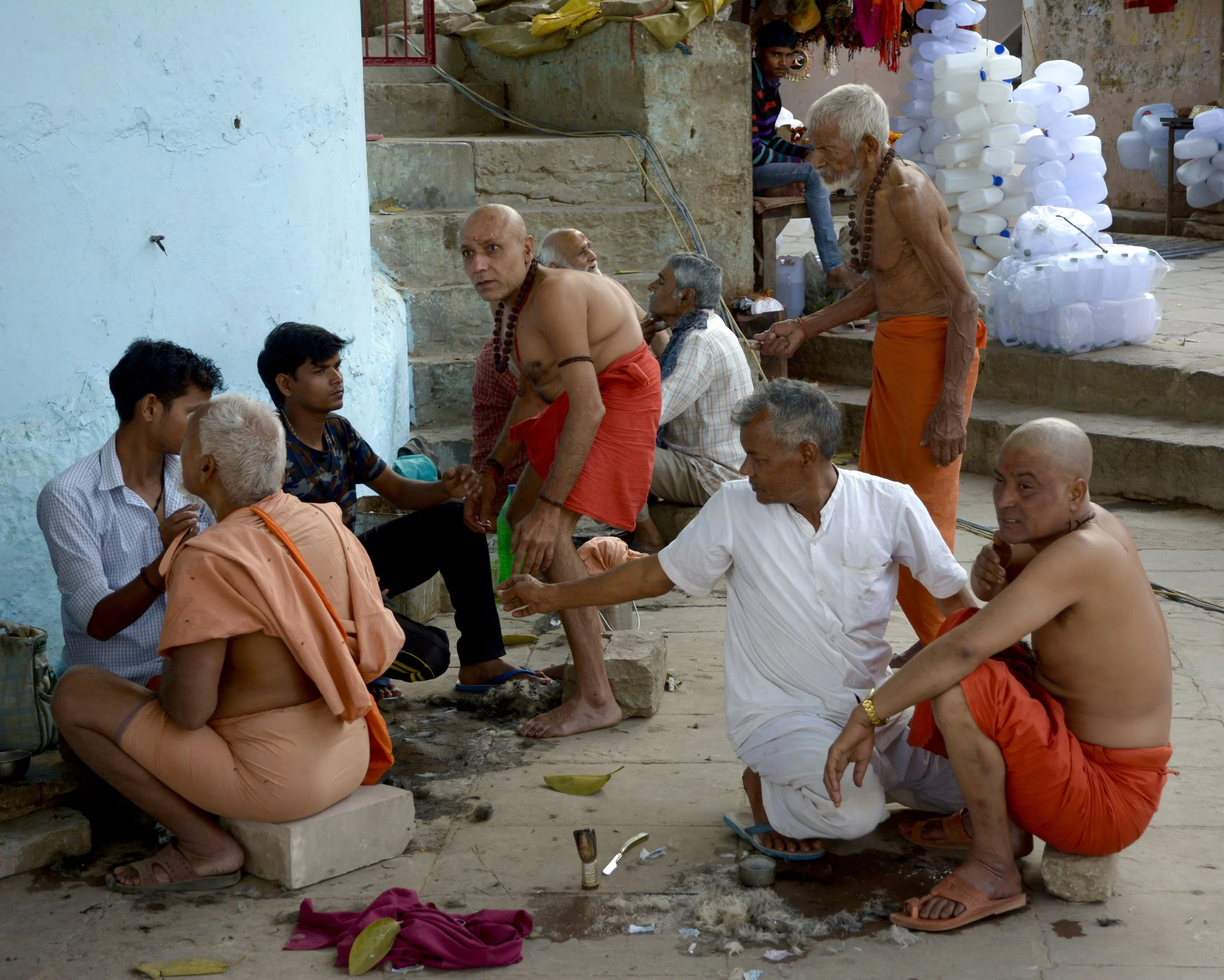 Sadhus and grieving family members having their heads shaved.