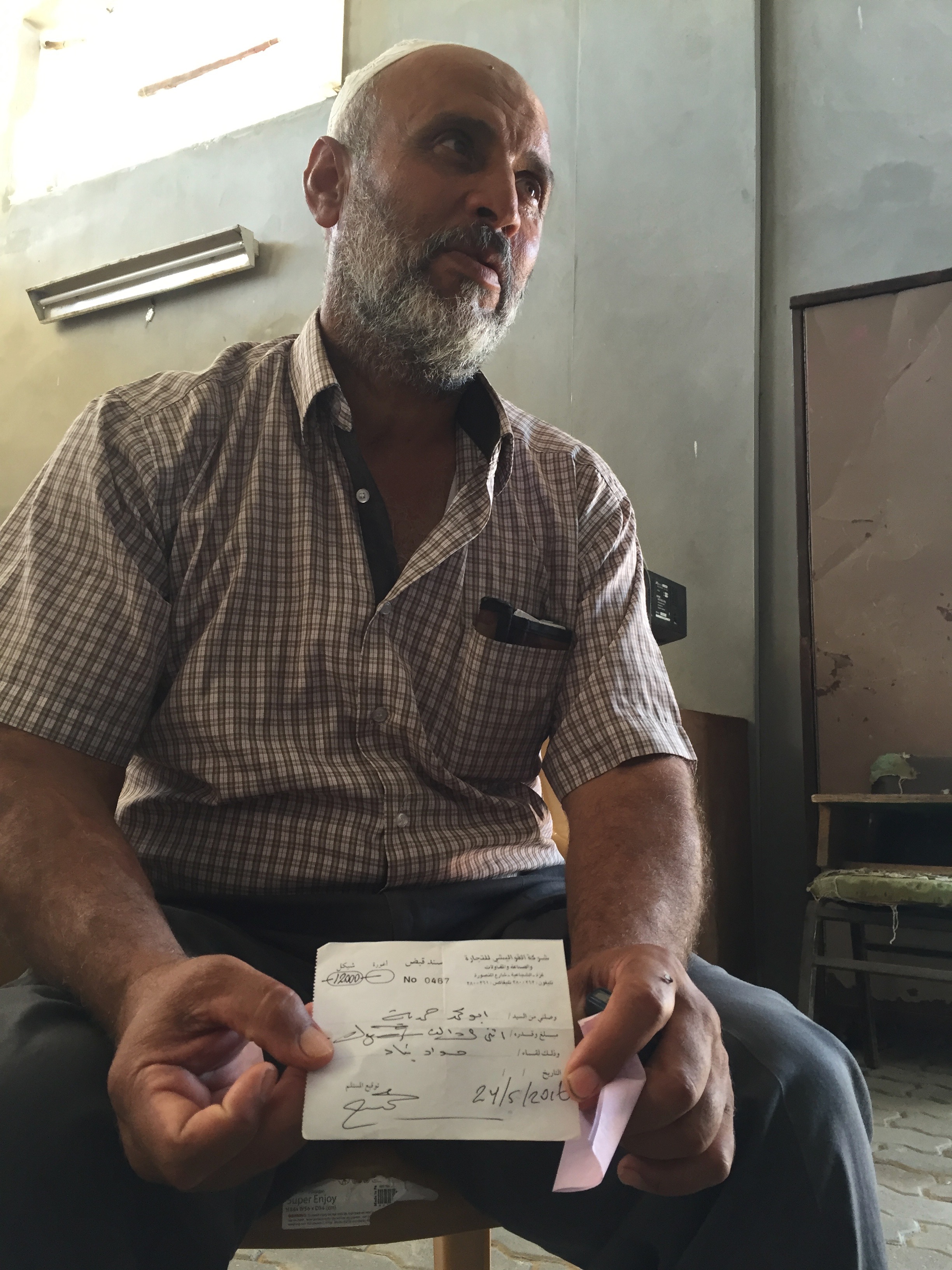  SHUJAYA | Moussa's entire four-storey home was destroyed during the 2014 Gaza war. He shows us a receipt proving he paid the money acquired from a Kuwaiti reconstruction fund to a cement provider in Gaza, but he says he is still waiting for the deli