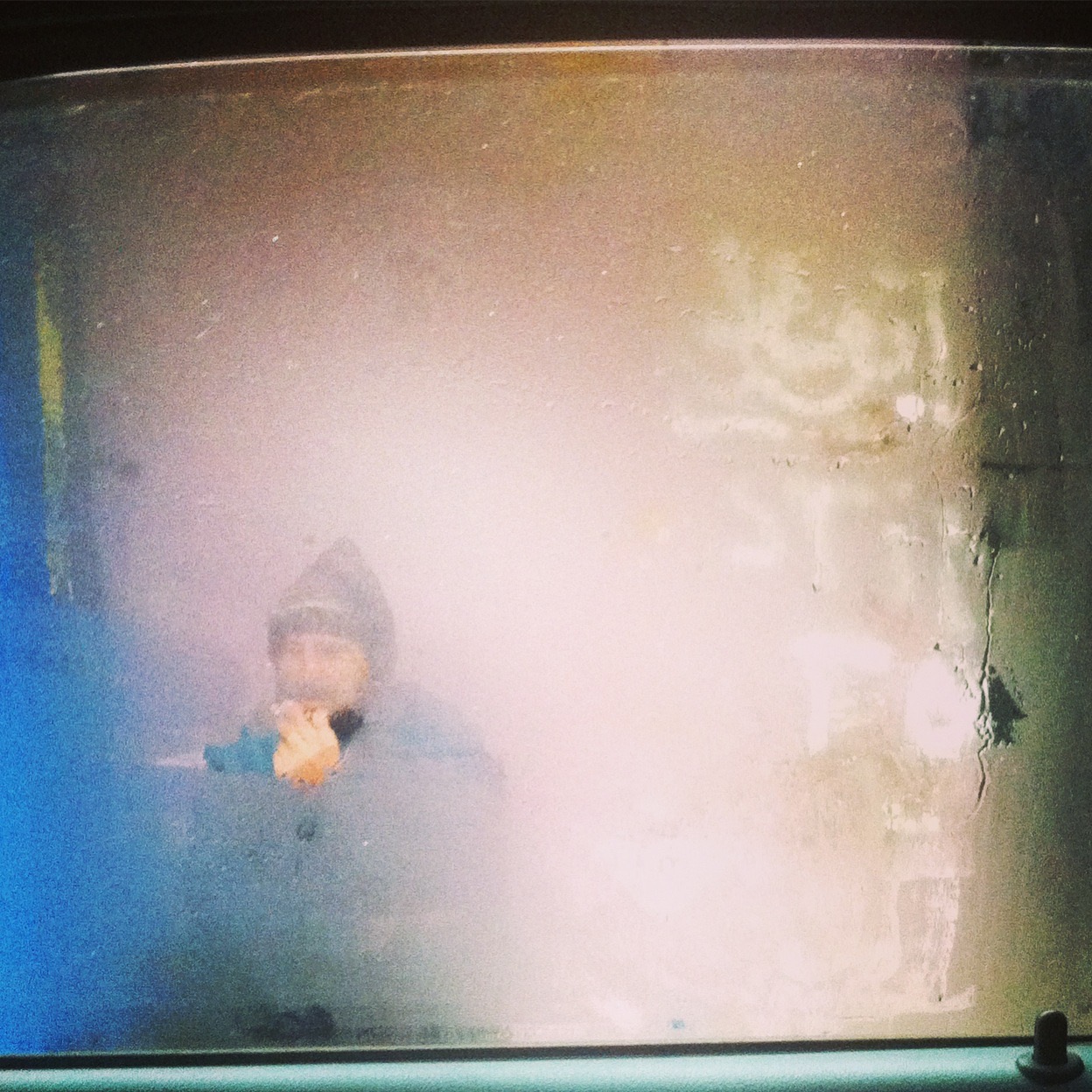 MINA | Man smokes under an awning during a winter rainstorm in northern Lebanon. February 12, 2015. 