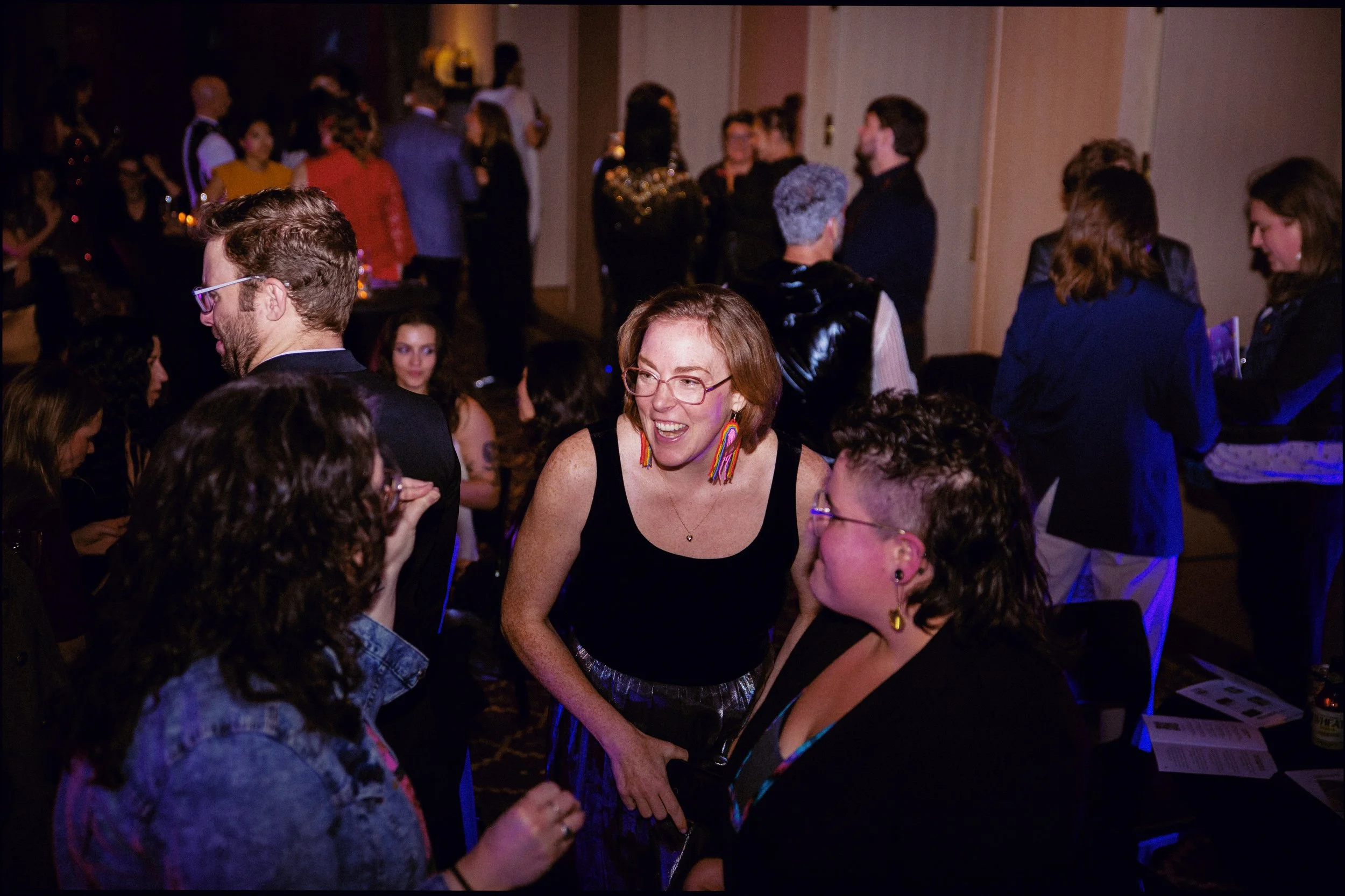 A crowded room, folks gathering and having fun