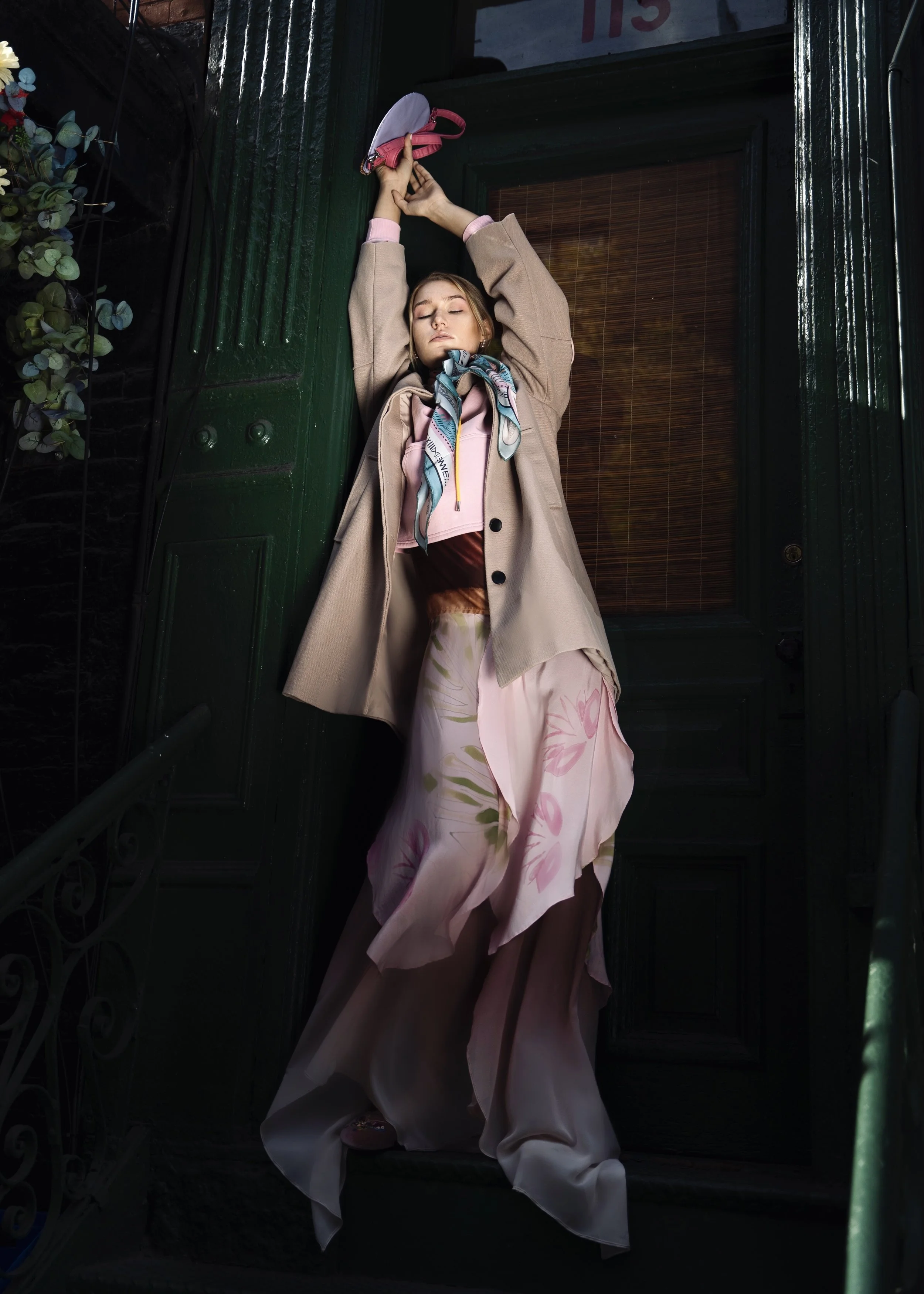 Woman in pink coat by green door