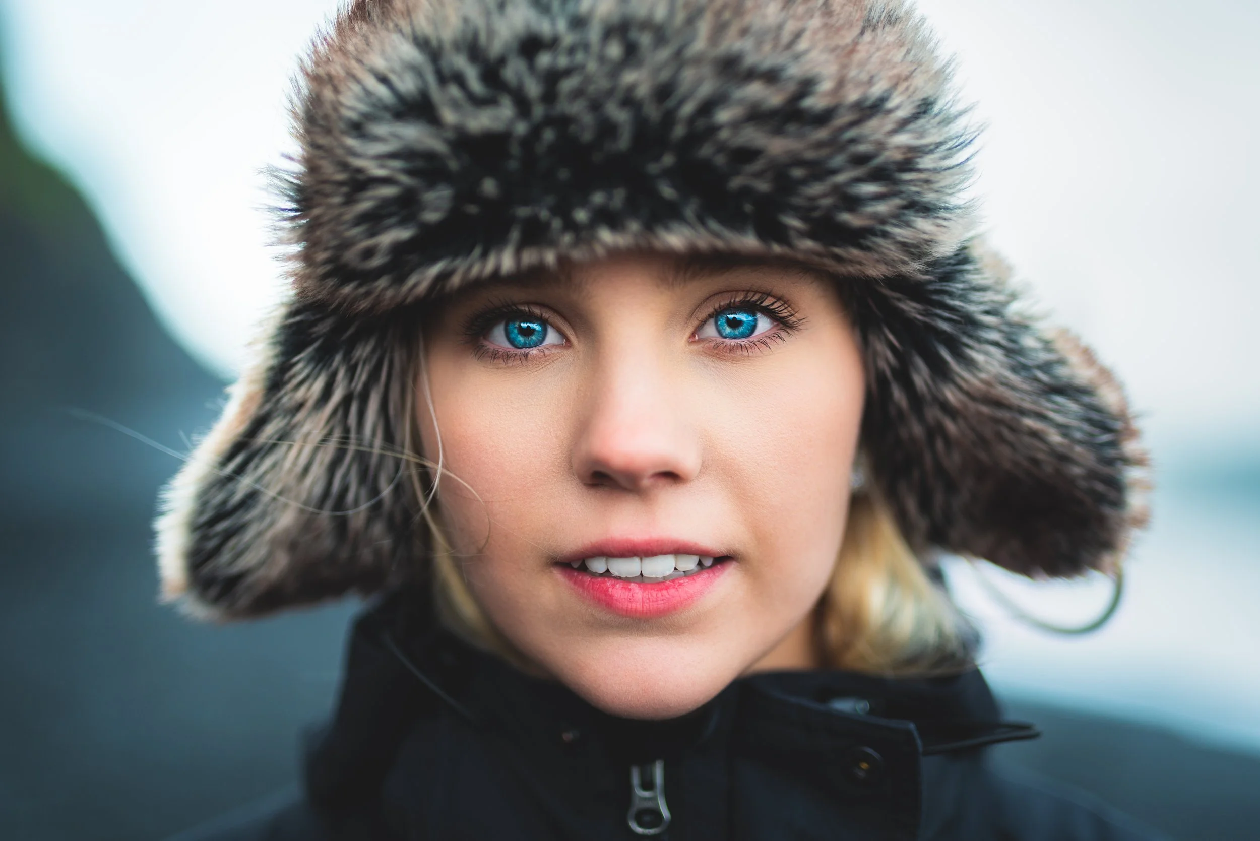 Close-up portrait with striking blue eyes wearing fur hat