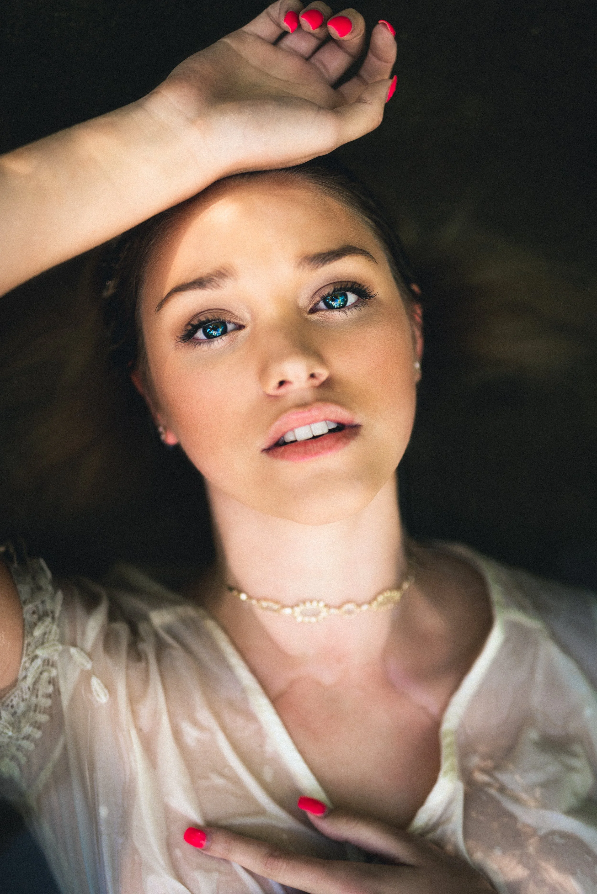 Close-up portrait with hand over forehead in sheer fabric