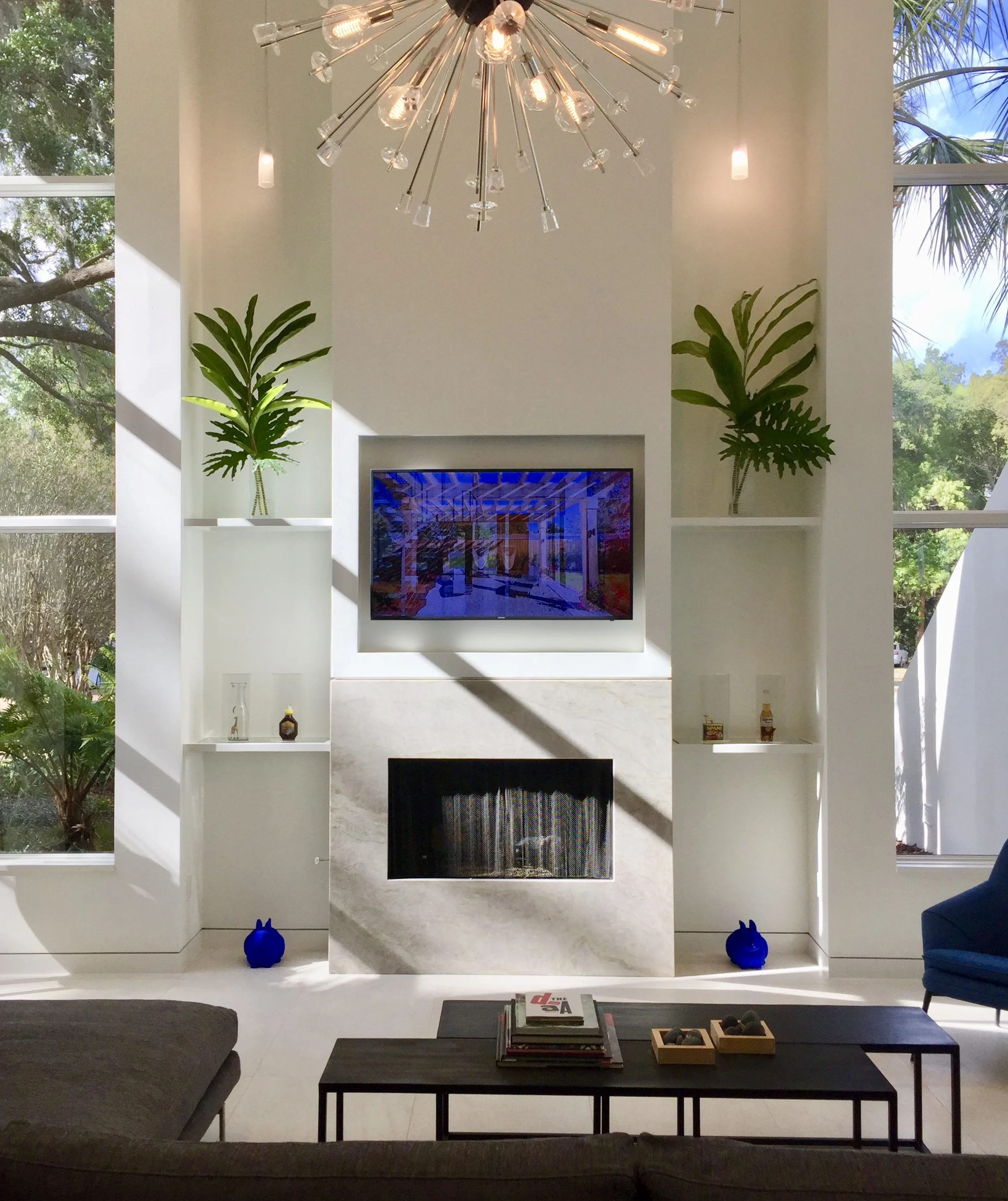 Sky and trees envelop this beautiful high-ceiling living room. "Blue Bunny" hand-painted sculpture $495. each