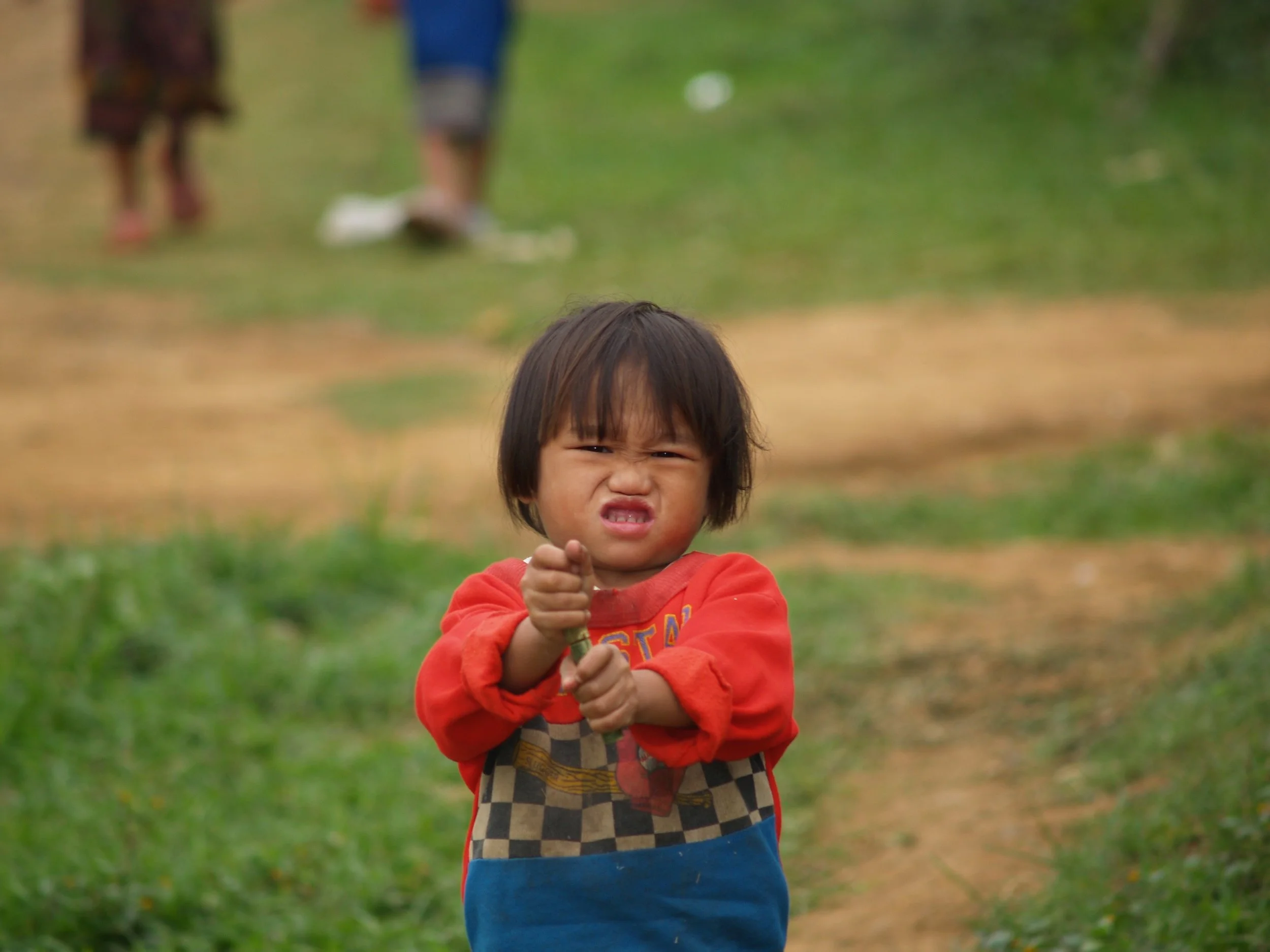 image: Laos 2005. Sometimes so many things are frustrating. I can relate to that. she tried for a long time to unscrew her toy.