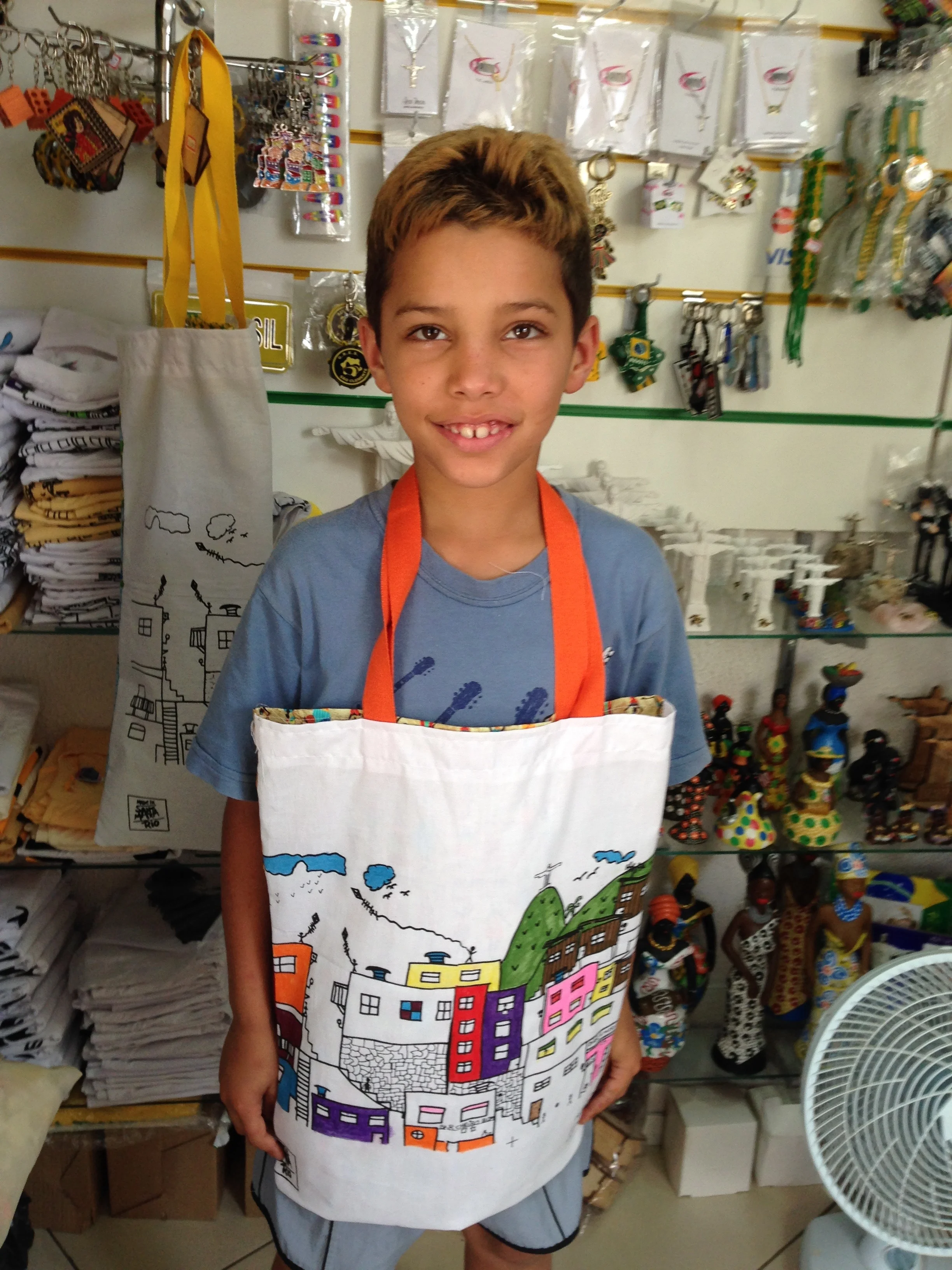 image: Rio De Janeiro in a favela. The little boy and i spend some time painting the bag and the tank top I bought. He was shy and sweet. I hope he will be ok.