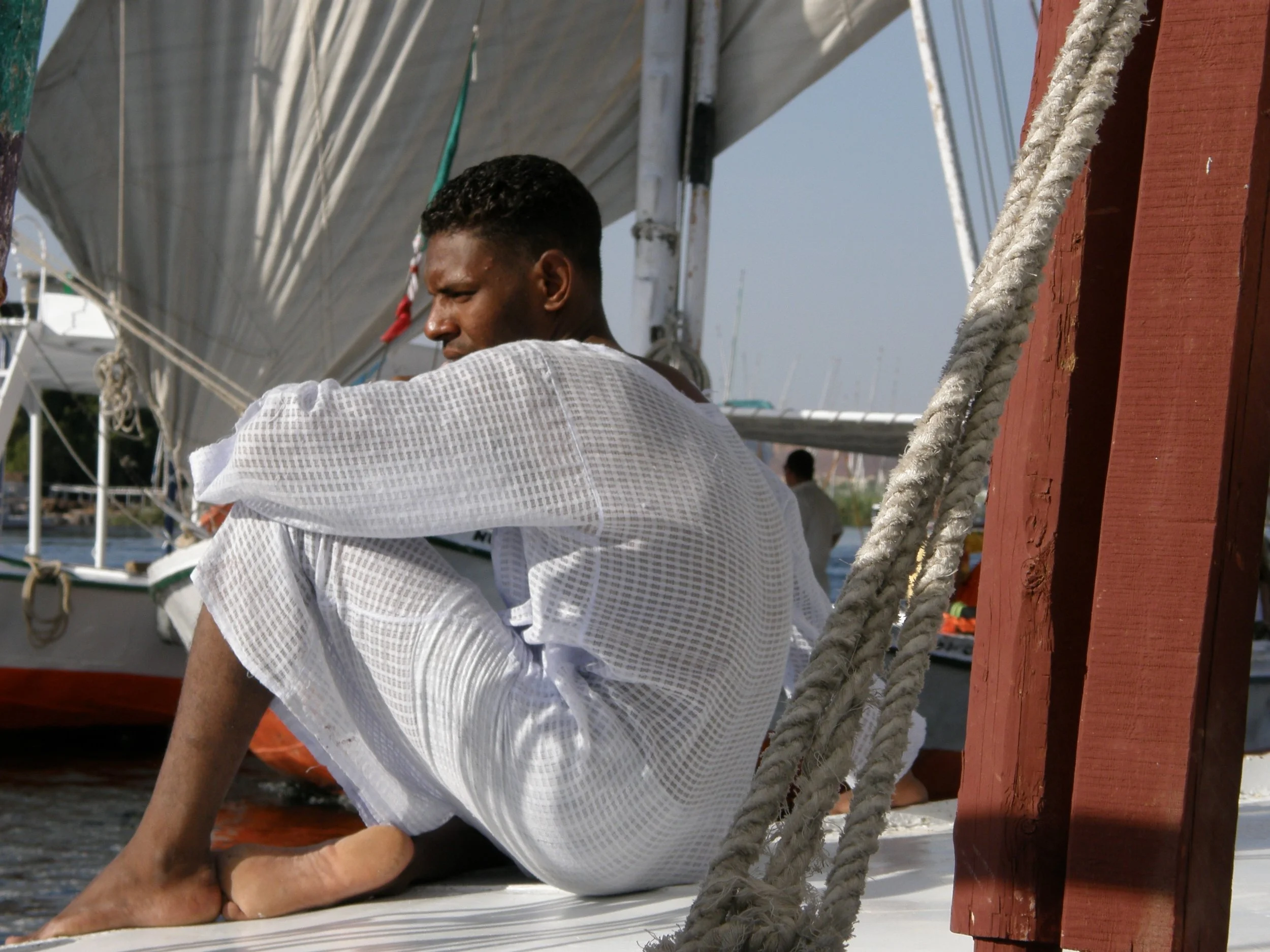 Contemplating on the Nile, a handsome Nubian man on a felucca in Aswan. I couldn't resist and bought a jellabiya just as his. I wear it and magically land on the Nile. 
