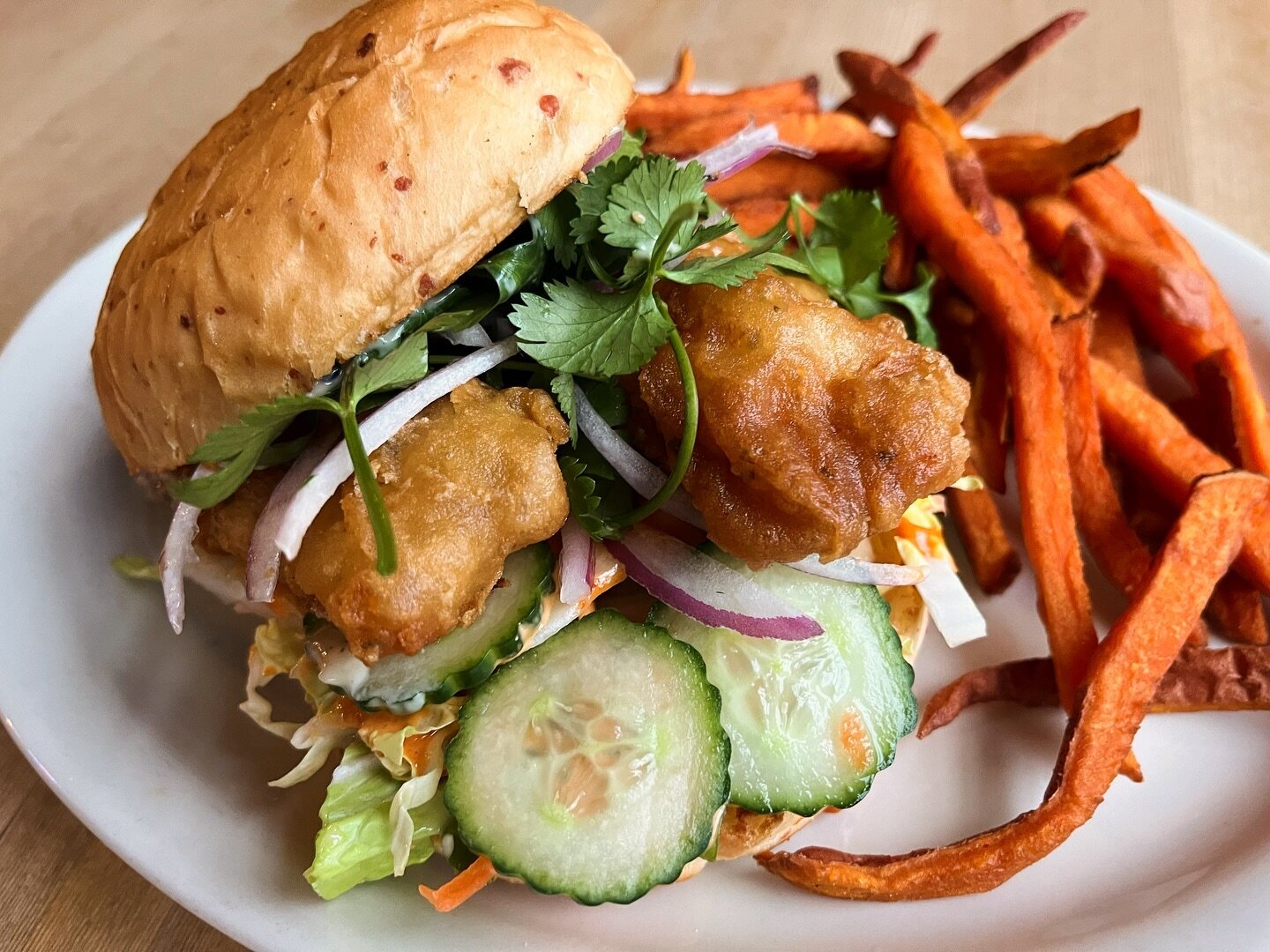 Last call for our Saigon Sandwich&mdash;Beer battered cod on our house Parmesan bun with Asian slaw, Korean aioli, marinated cucumber, fresh red onion, cilantro and crunchy sesame aioli. Served with your choice of side but we always suggest our sweet