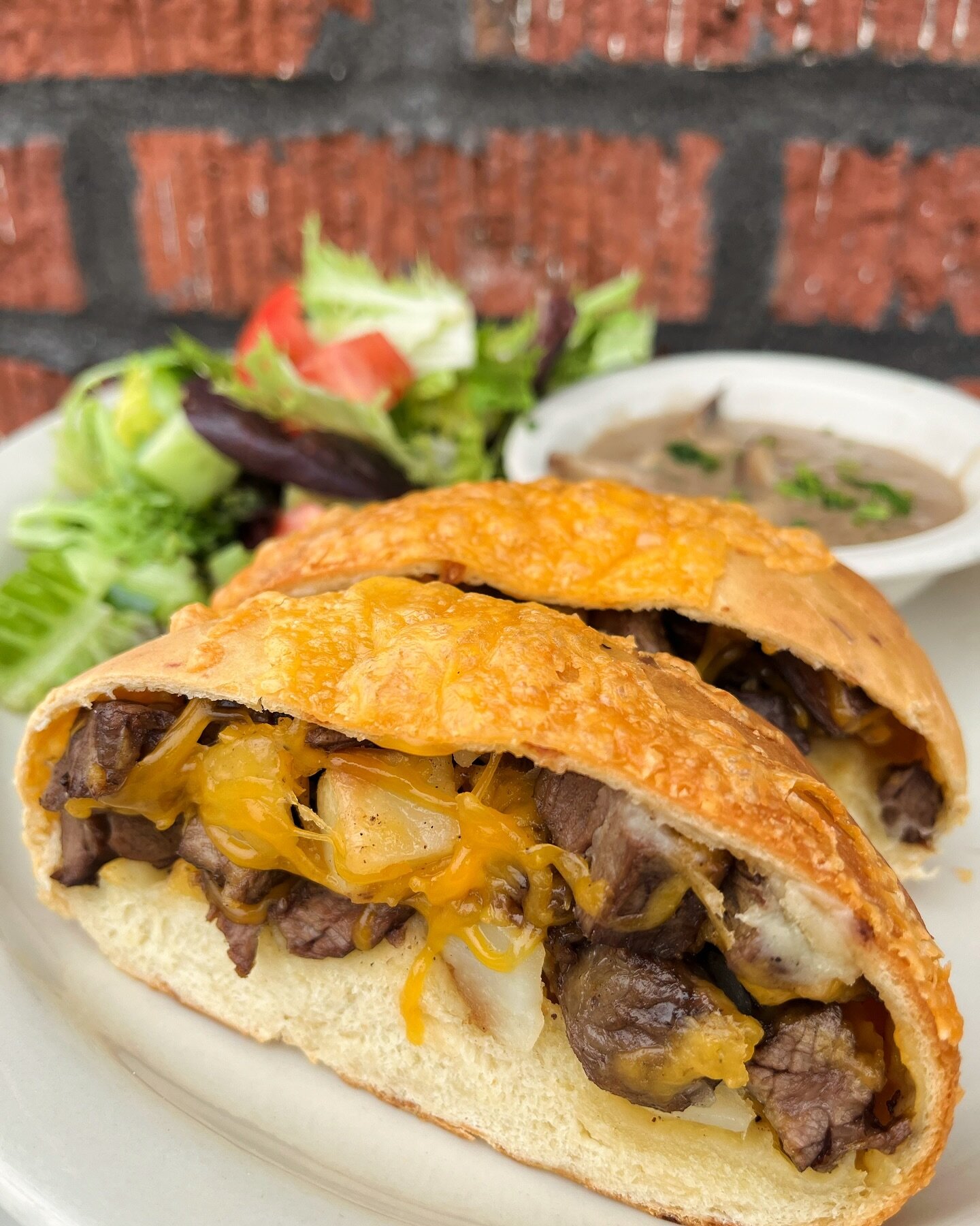 New lunch and dinner special! Steak Hand Pie&ndash;Skirt steak with potato, cheddar cheese &amp; green onion baked in soft parmesan bread. Served with gorgonzola mushroom gravy for dipping &amp; a green salad.