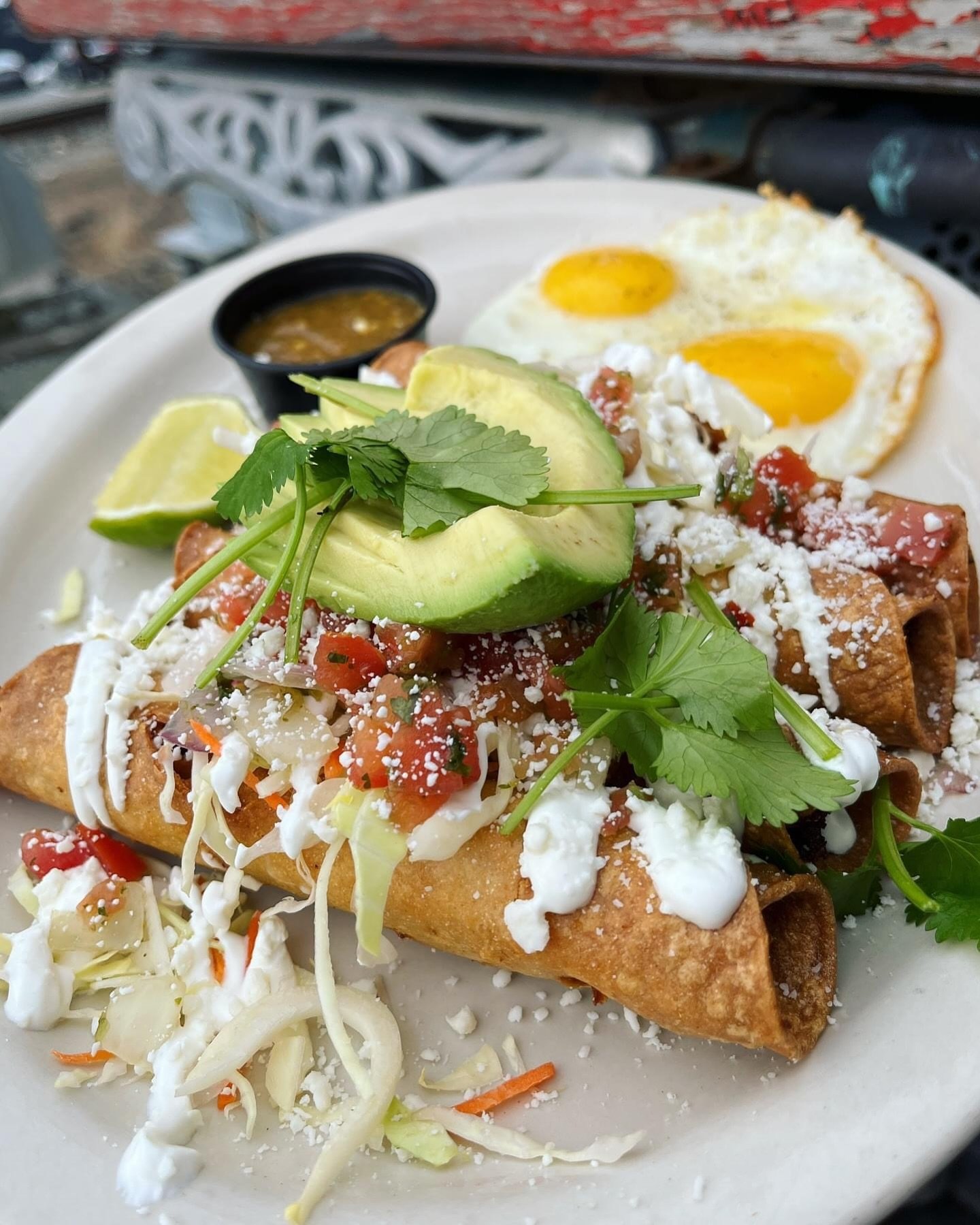 Taquitos for breakfast! 🤤 Dorados y Huevos&ndash;Crispy fried ground beef and potato taquitos topped with cabbage, pico, sour cream, cotija, avocado &amp; cilantro, served with two eggs and roasted salsa.