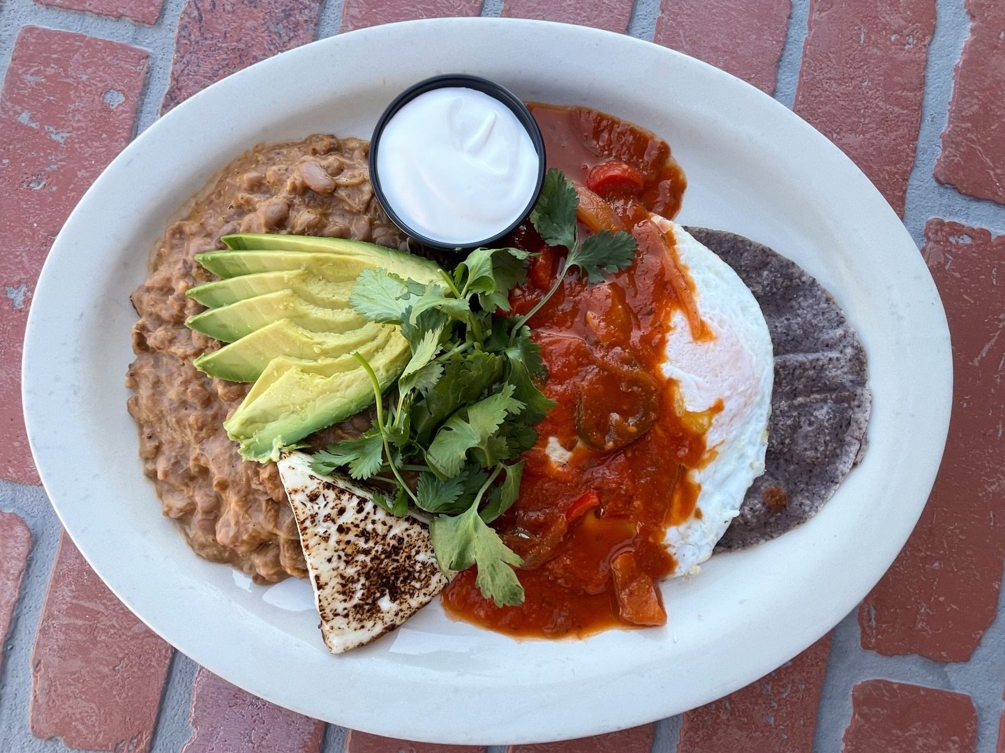 New breakfast special starts today! 🍳 Huevos Rancheros&mdash;El Molino&rsquo;s blue corn tortillas topped with two eggs &amp; salsa ranchera. Served with grilled panela, frijoles puercos, avocado, cilantro and sour cream.