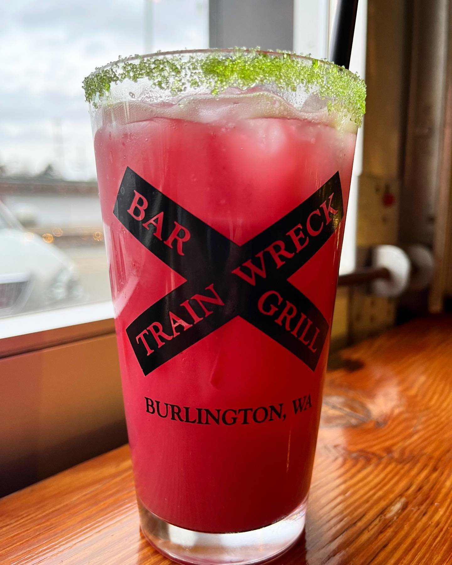Come in for #margaritamonday at Train Wreck! Our Holiday Colada is made with cranberry pur&eacute;e, tequila, and cream of coconut&mdash;served with a festive green sugar rim.