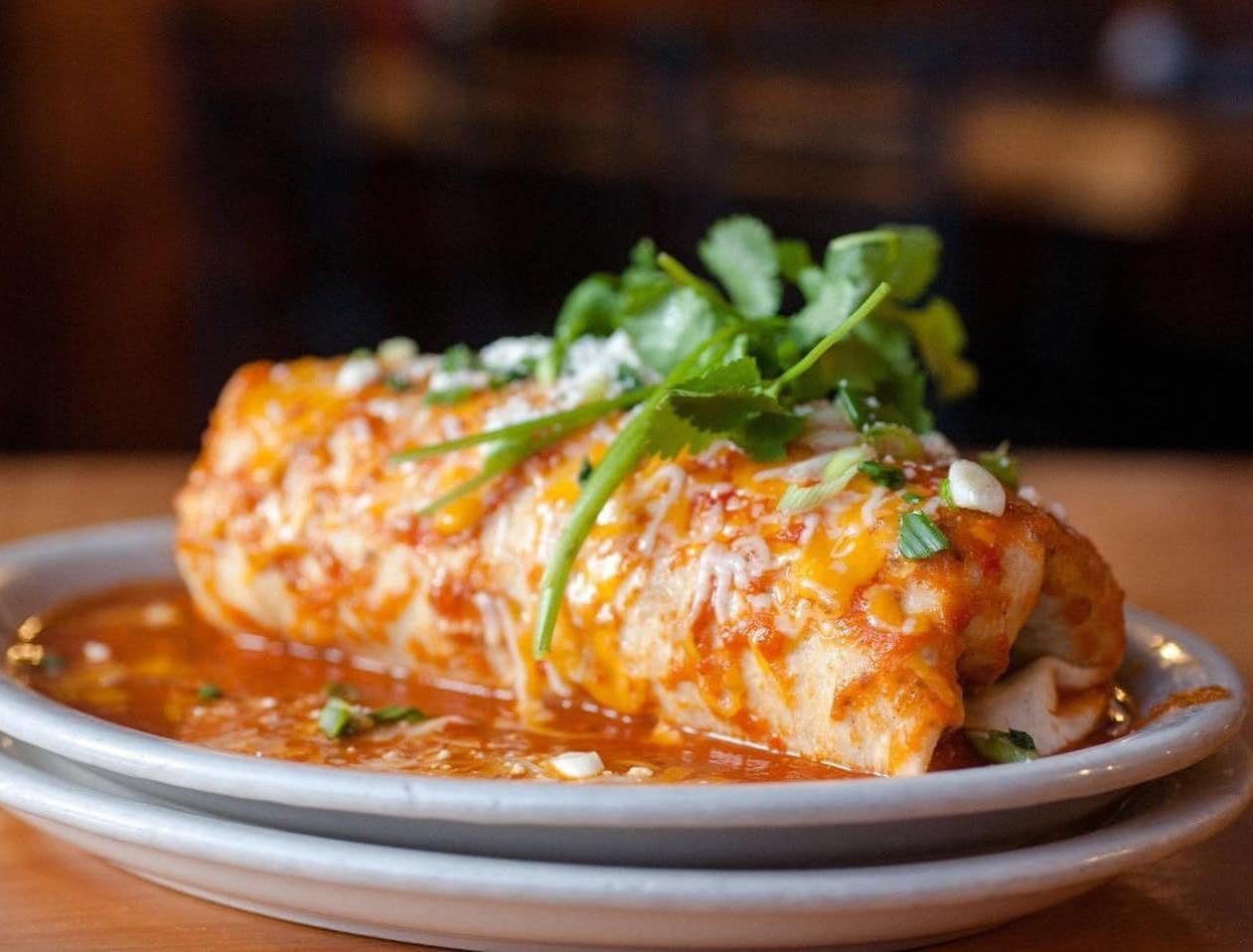 🌯 Train Wreck Breakfast Burrito&ndash;A warm 14" flour tortilla filled with scrambled eggs, potato, avocado, bacon, sausage, pico de gallo, jack &amp; cheddar cheeses. Smothered in house red chili sauce and topped with scallions, cilantro &amp;