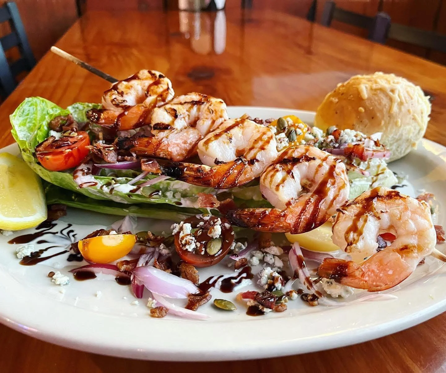 New lunch and dinner special! Our Prawn Wedge Salad is a romaine wedge topped with blue cheese dressing, bacon, red onion, tomato, pumpkin seeds, blue cheese crumbles and balsamic glazed grilled prawns. Served with a rosemary roll, $22.