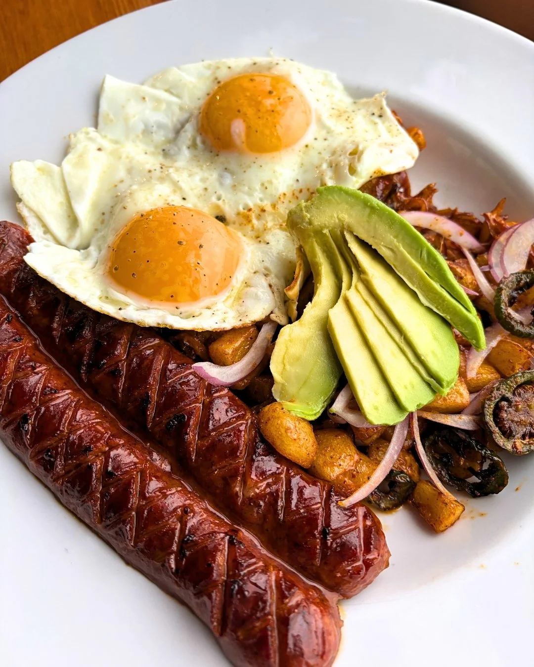 Turn up the heat with our Bayou Hash! Jack Mountain Meats andouille sausage served over adobado grilled potatoes with jalape&ntilde;o and red onion, drizzled with chipotle aioli. Topped with two eggs and fresh sliced avocado for the perfect balance o
