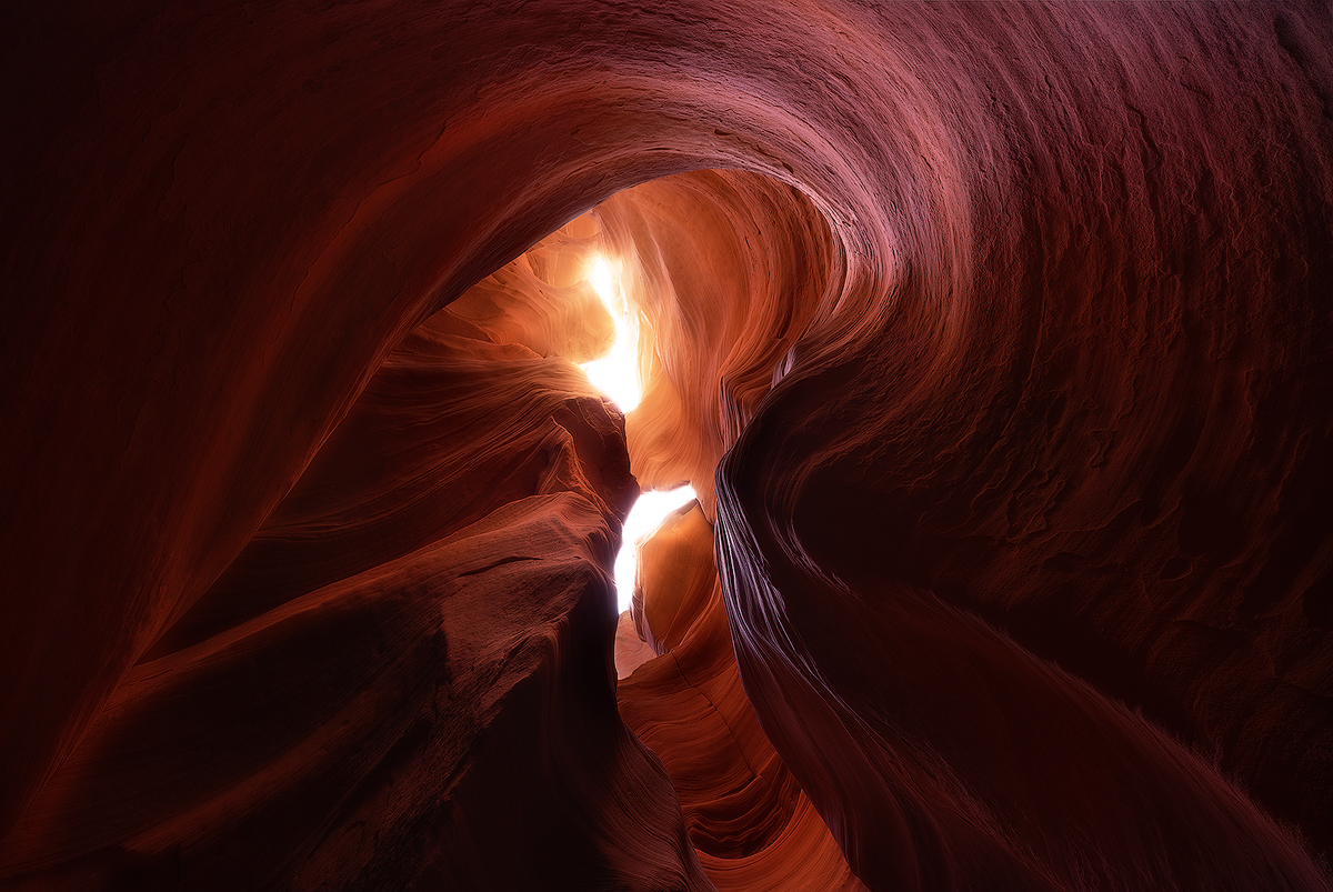"Navajo Spirit" -- swirling sandstone patterns carved by centuries of flash floods frame a daylight opening in Canyon X Nikon D800e, Nikon 14-24 @ 16mm. Multiple exposures for depth of field and to reduce glare