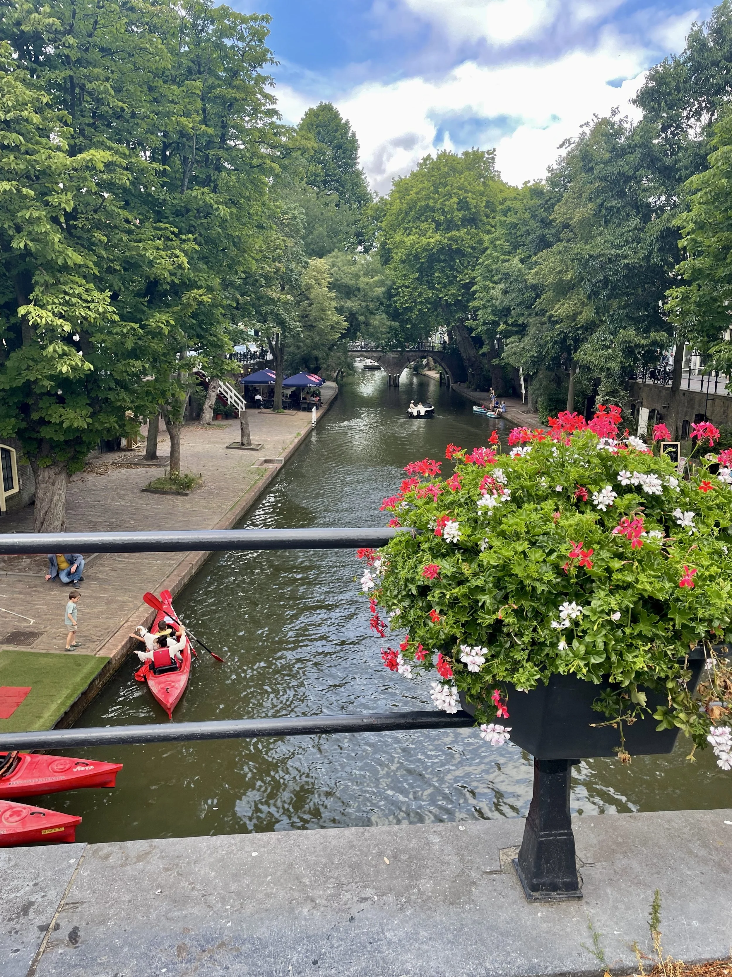 A charming view onto the Utrecht canal, with kids and dogs on their canoe ride down the water.