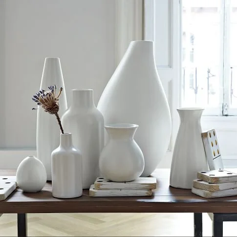 A designed collection of decorative white pottery and oversized dominos as accessories displayed. Art is the signature of civilization. #DomaineLuxe