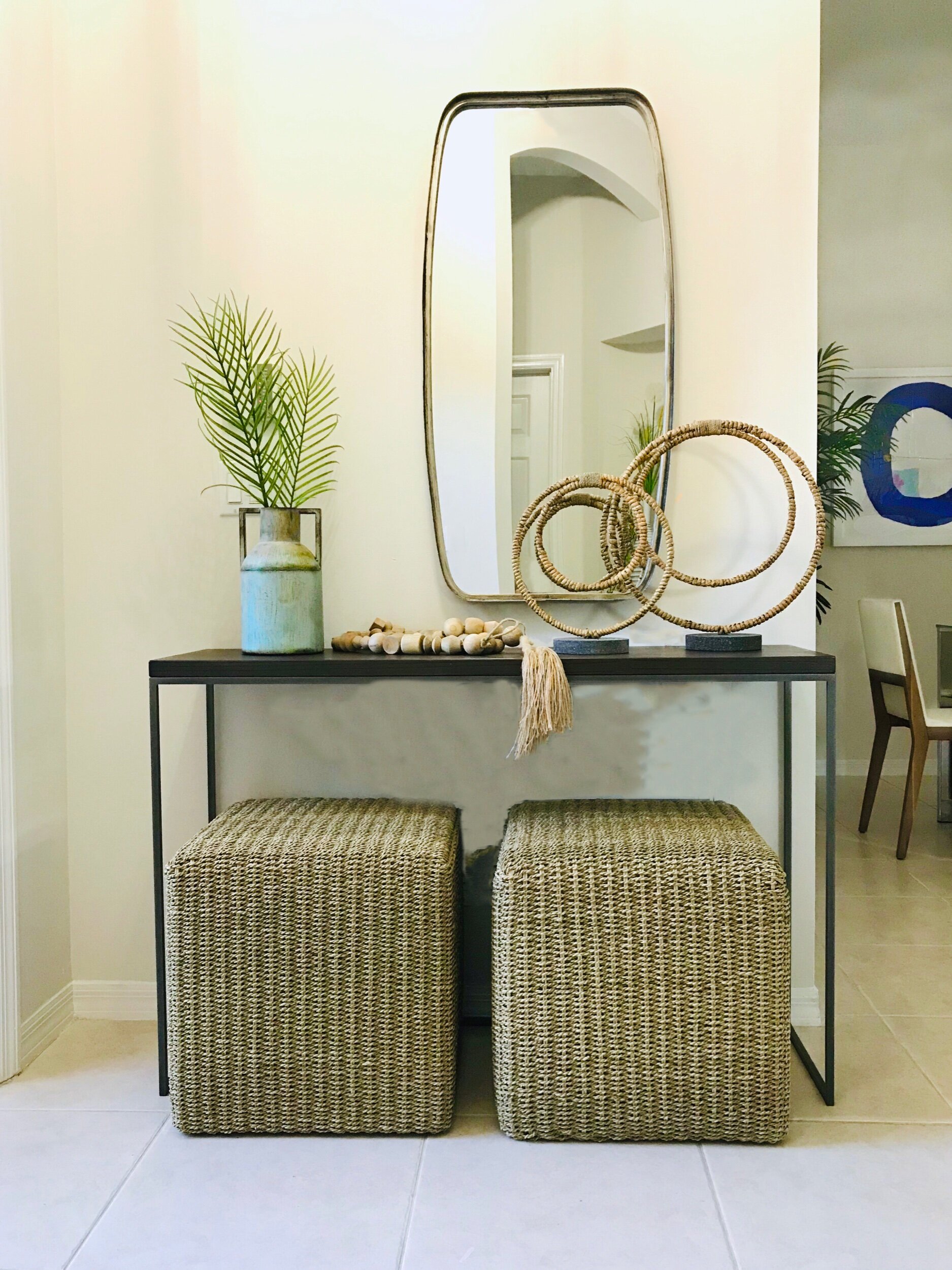 Casual modern foyer table with natural ottomans  and styled with decor