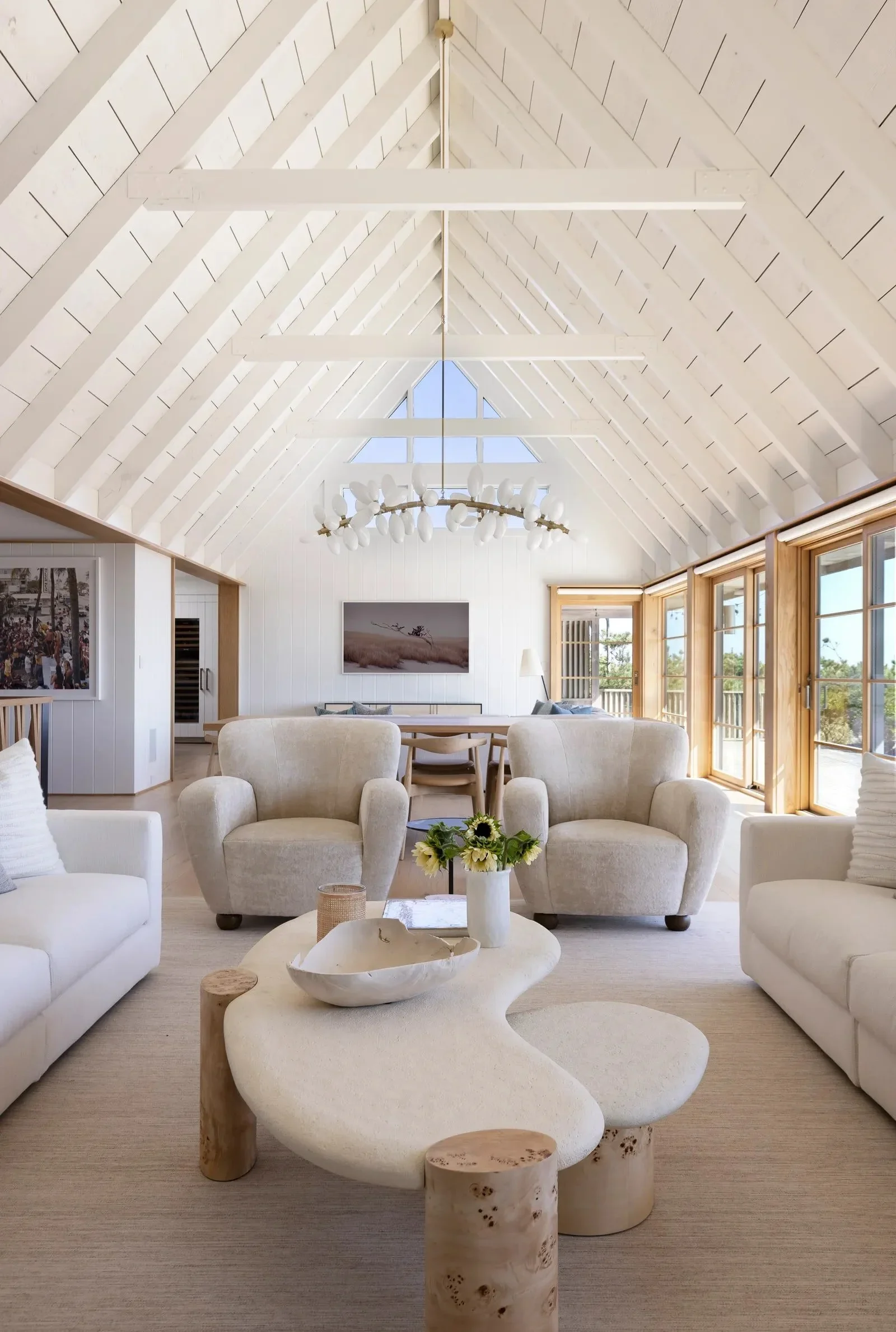 Vaulted coastal living room with warm white seating and organic coffee table with Palm Beach ocean view.