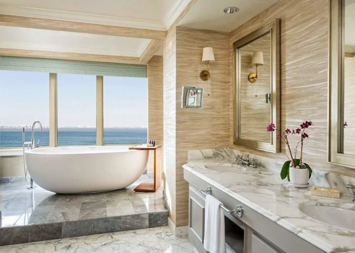 Ocean view luxury bathroom with freestanding tub and marble vanity