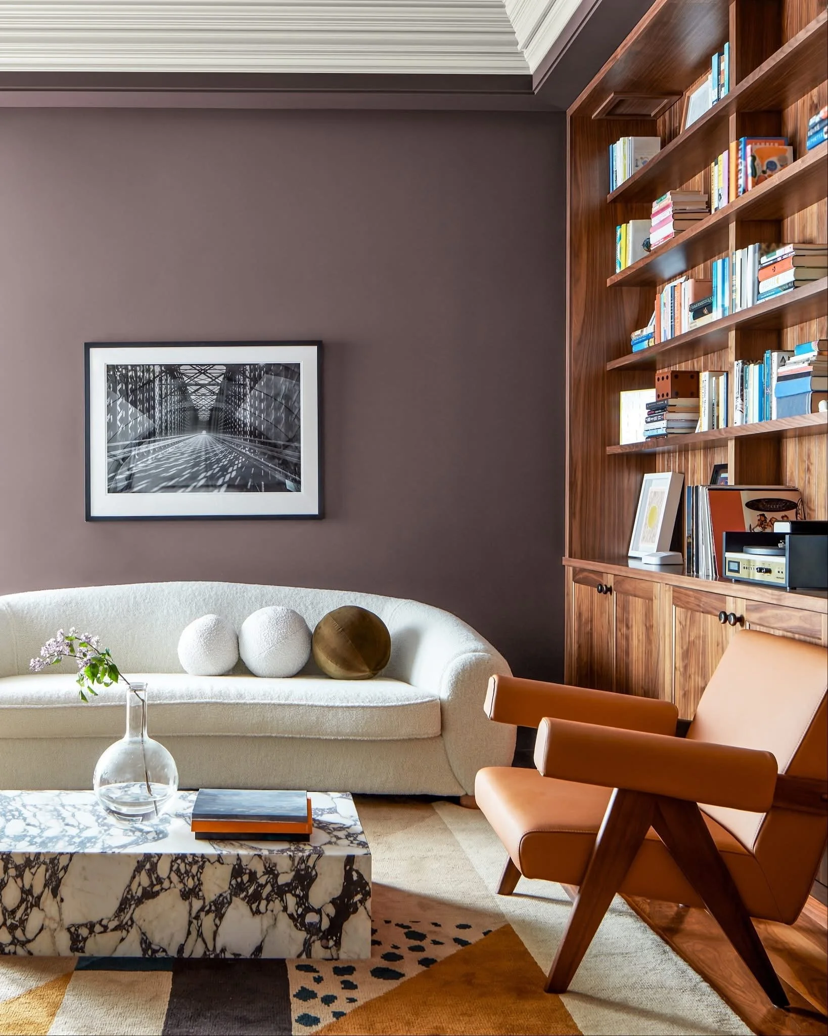 This modern mauve paint color is the perfect backdrop to the Palm Beach living room seen here. The timeless sofa and chair, paired with the bold, natural marble cocktail table exemplifies color science in this design.